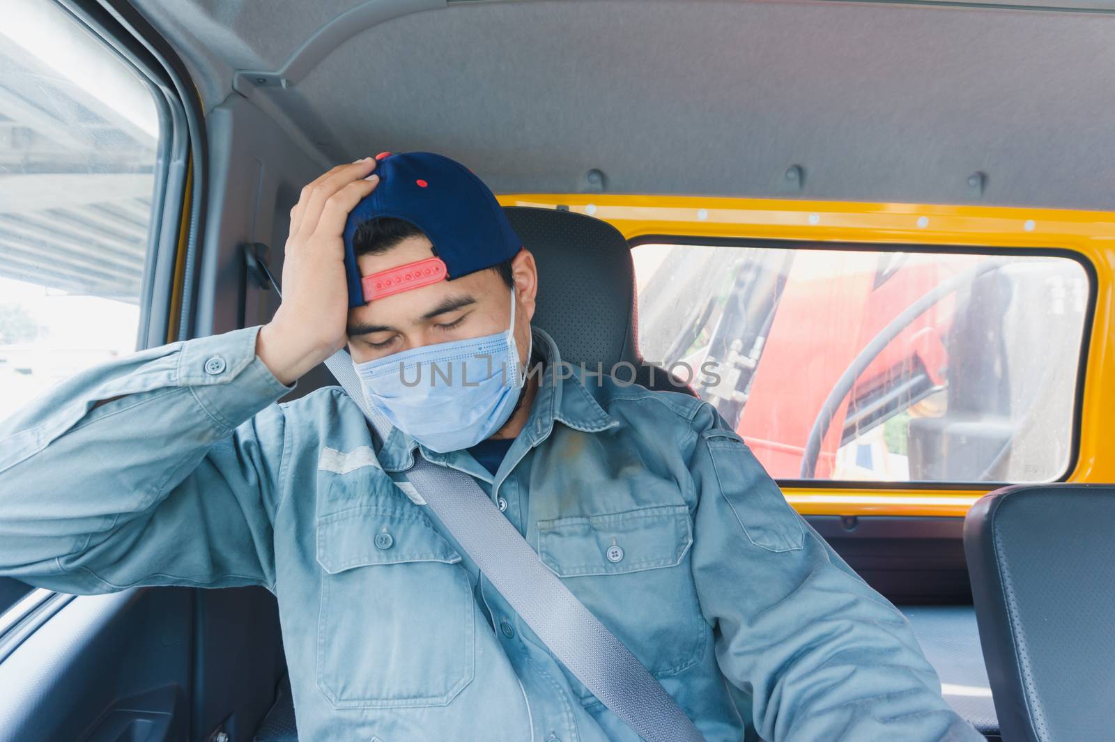 Close-up photos of Asian truck drivers wearing masks to protect against dust and the spread of the flu. Covid 19. Inside the car front