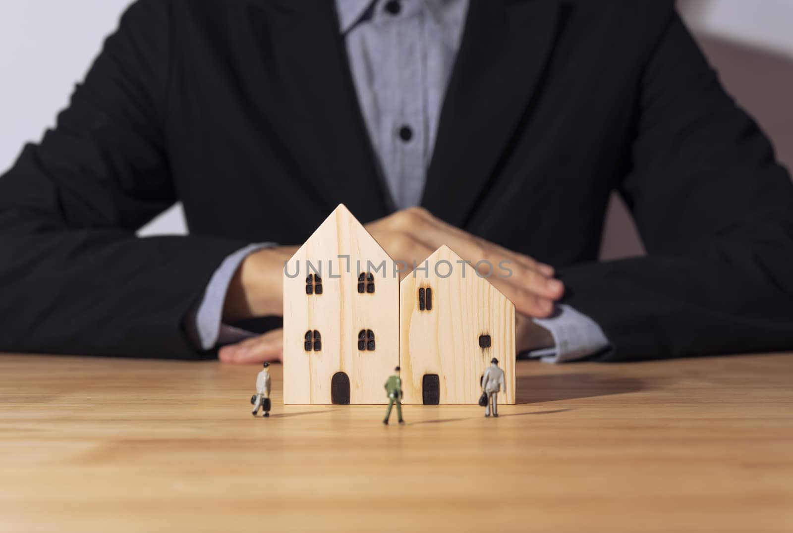 Business salesman agent offer wooden home. concept home and residence insurance.