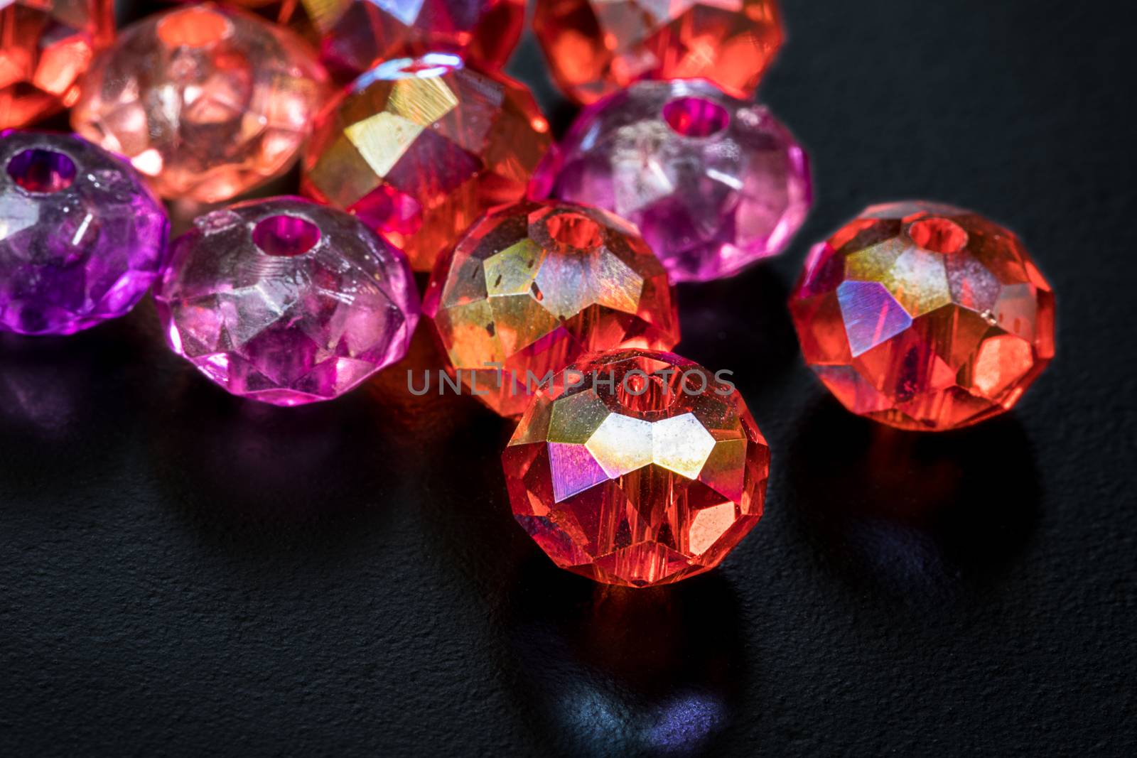 Macro shot of colorful beads on black background.