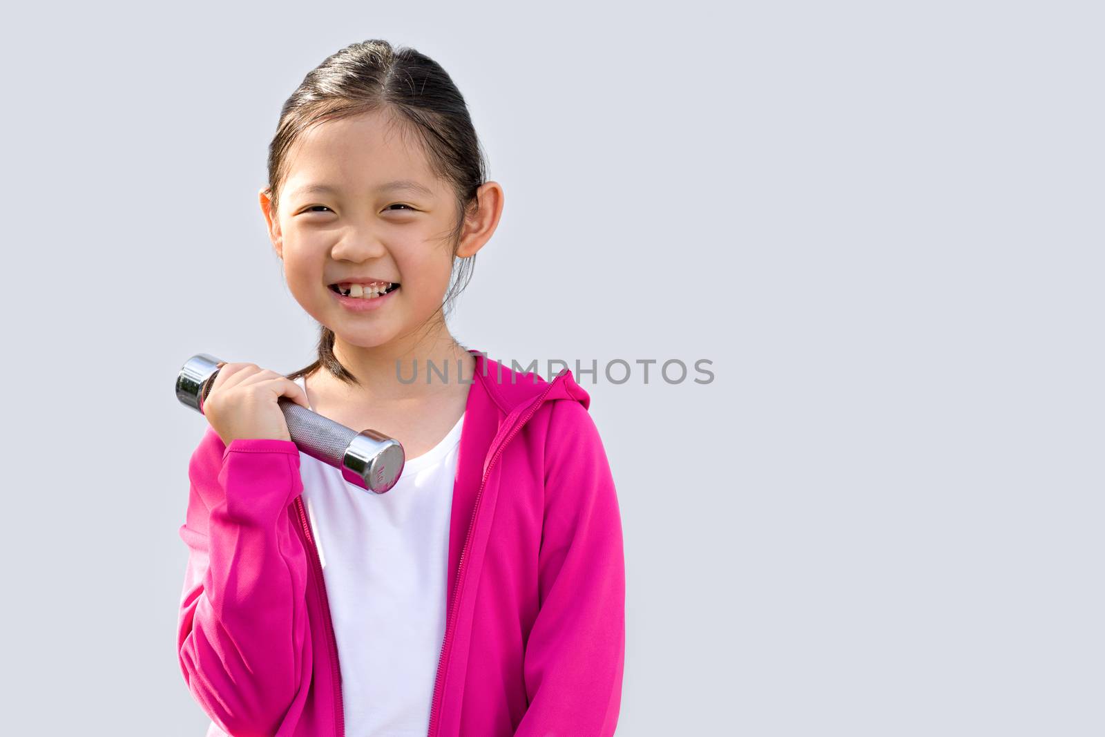 Studio shot of Asian kid wearing sweater holding dumbbell, isolated on white background.