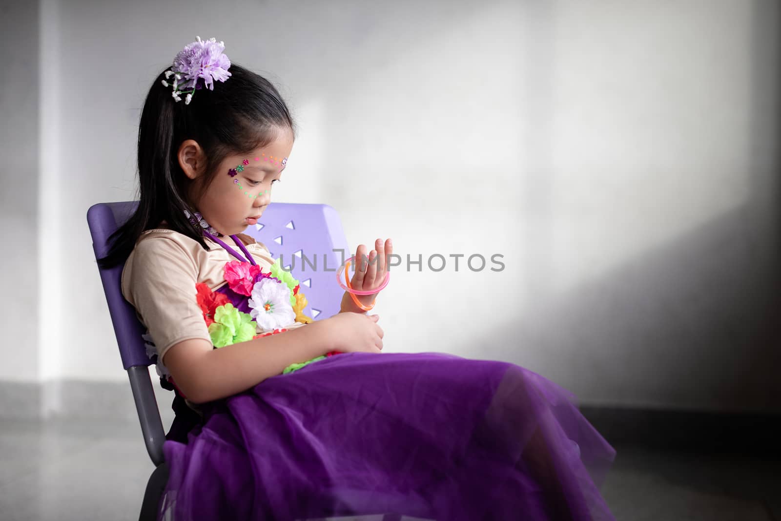 Abandoned lonely Asian child sitting alone on chair.