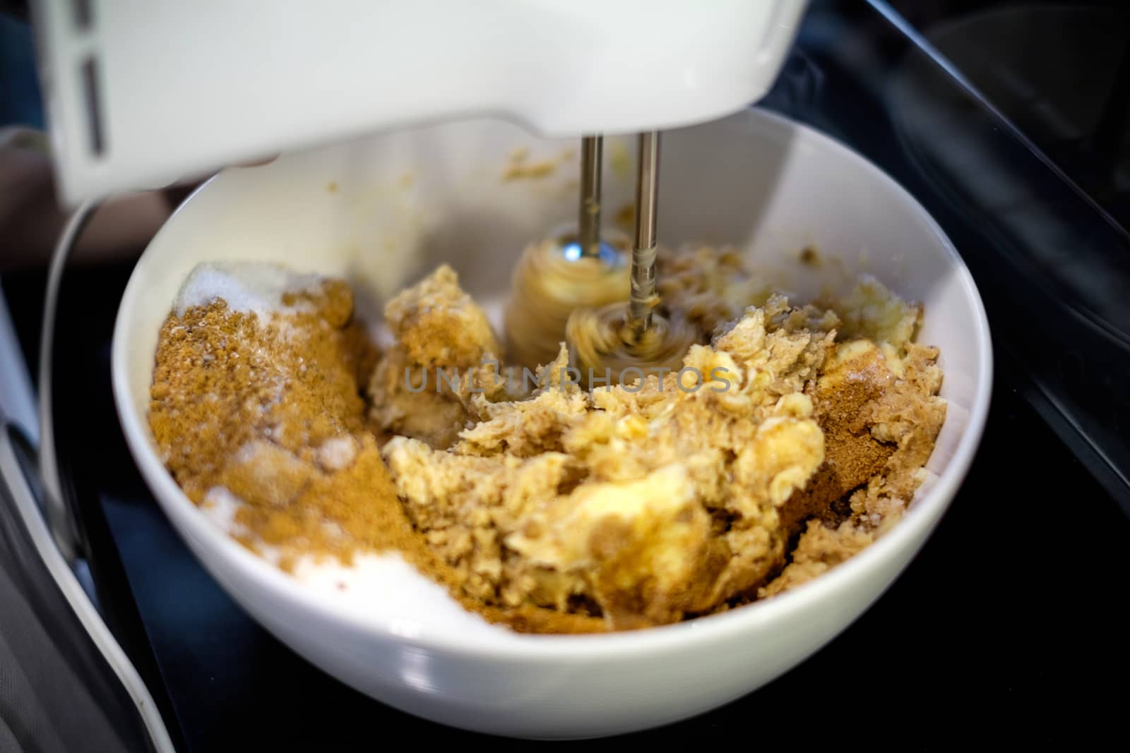 Mixer is mixing cookie ingredients in bowl.