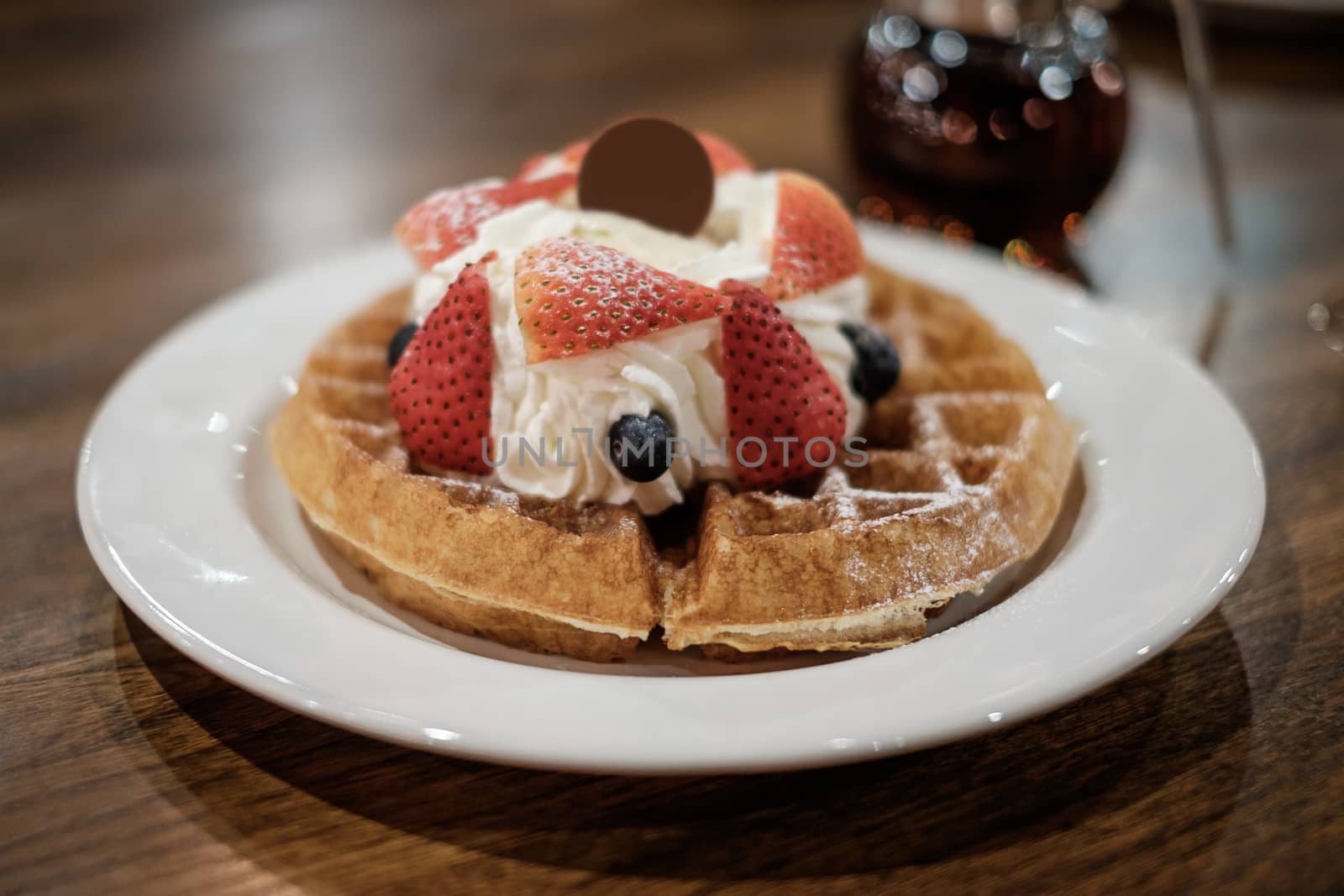Belgium waffle with fresh strawberry and whipped cream.