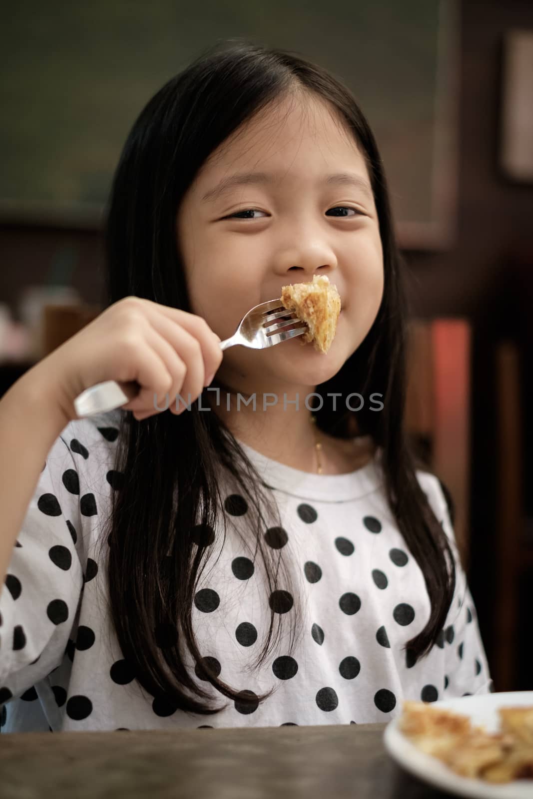 Kid eating pastry snack with smile in vintage.