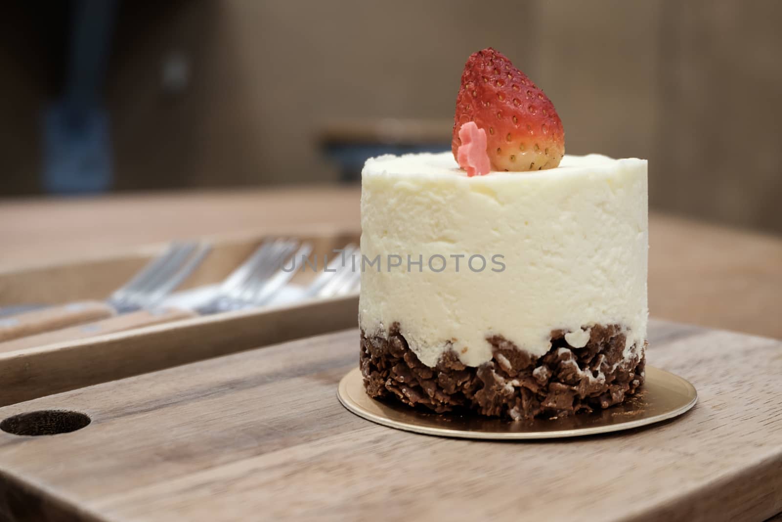 Fresh strawberry mousse cake dessert on wooden plate.