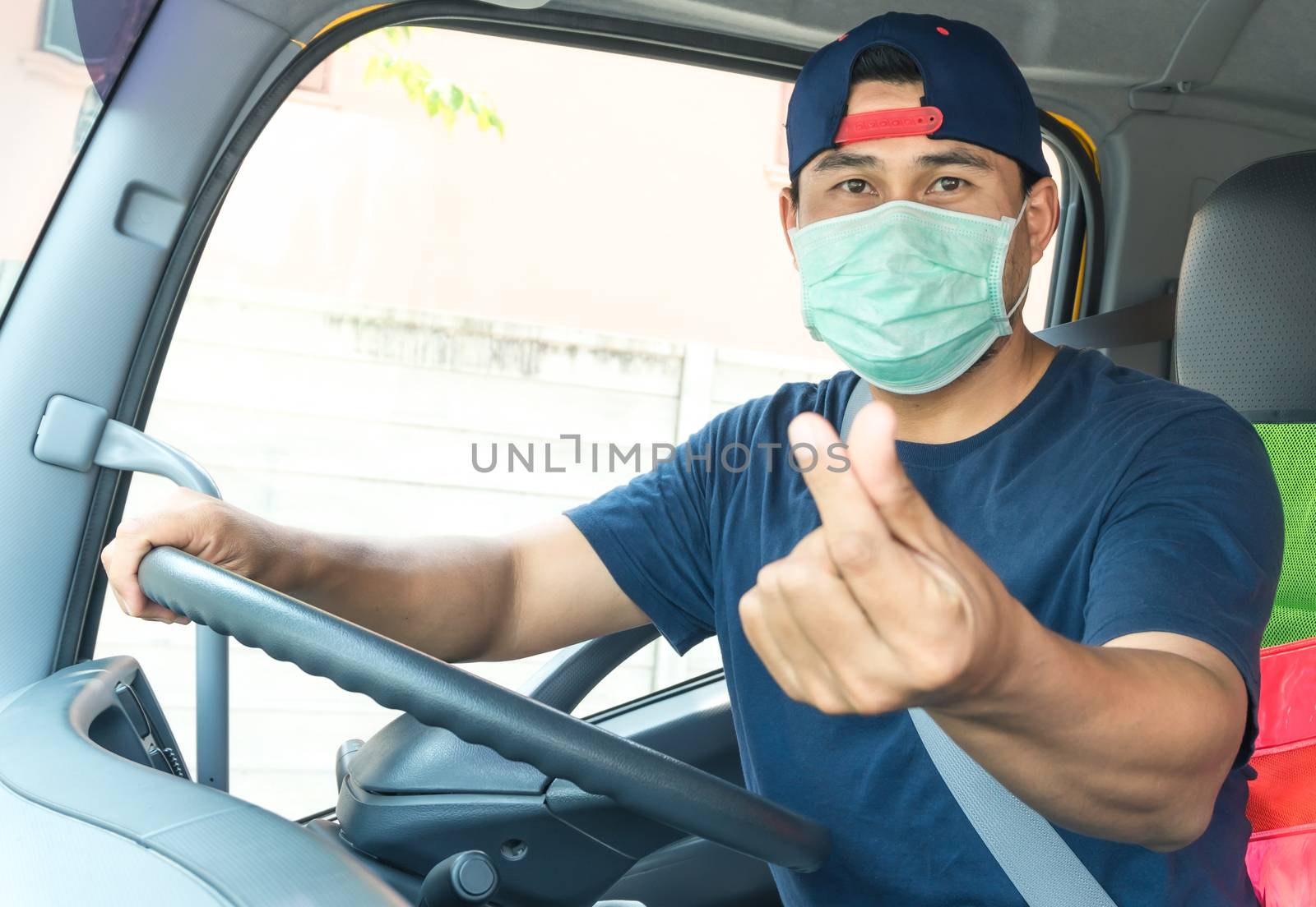 Close-up photos of Asian truck drivers wearing masks to protect against dust and the spread of the flu. Covid 19. Inside the car front