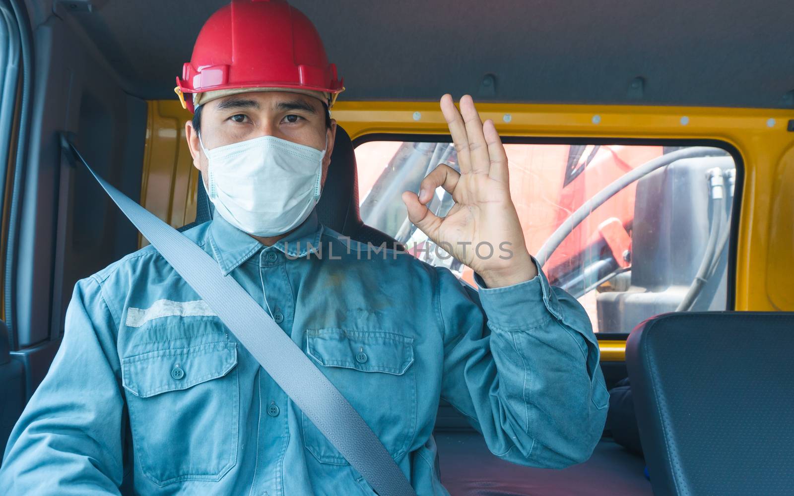 Close-up photos of Asian truck drivers wearing masks to protect against dust and the spread of the flu. Covid 19. Inside the car front