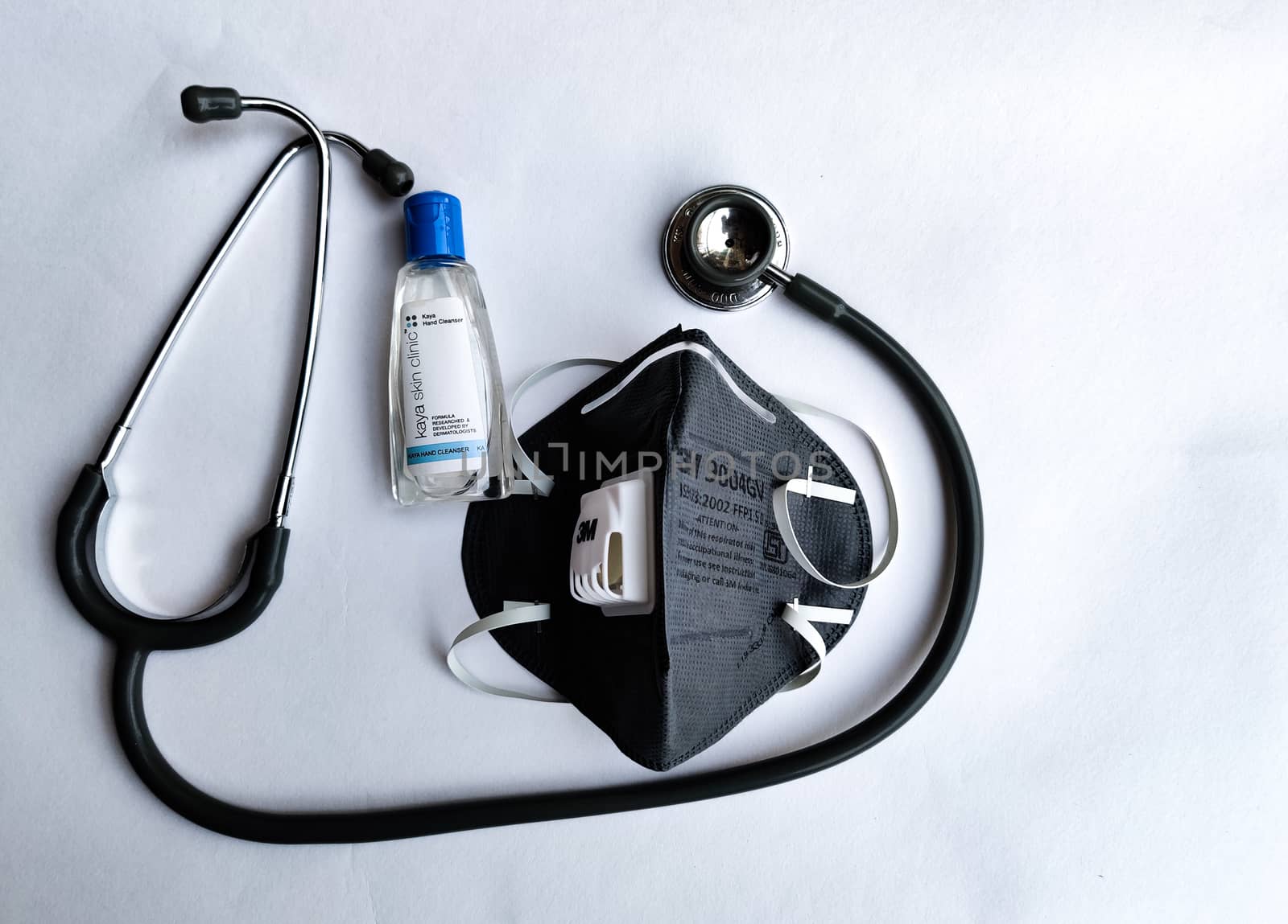 Milan, Italy, 2020. 3M Grey N95 face mask, sanitizer and stethoscope on a white background denoting doctor's Corona virus (Covid-19) safety kit to reduce the rate of spread of infections