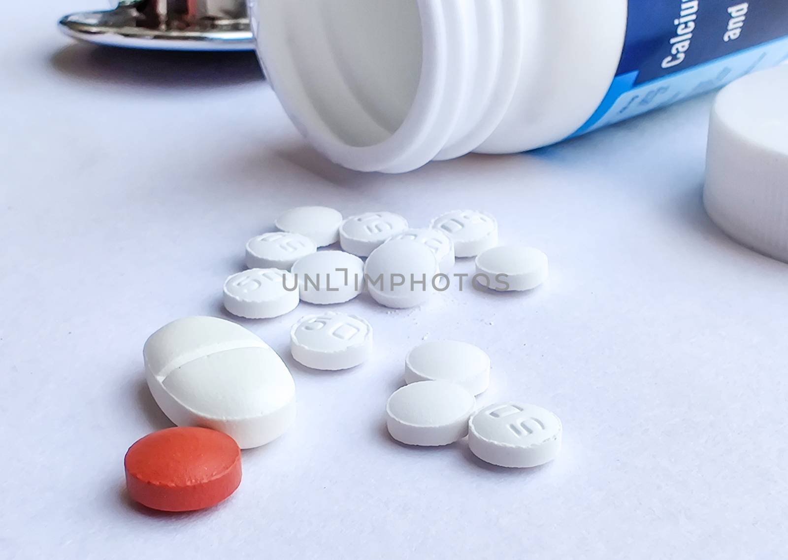 Pills spilling out of a plastic bottle and isolated on white background. Top view with copy space. Medicine concept