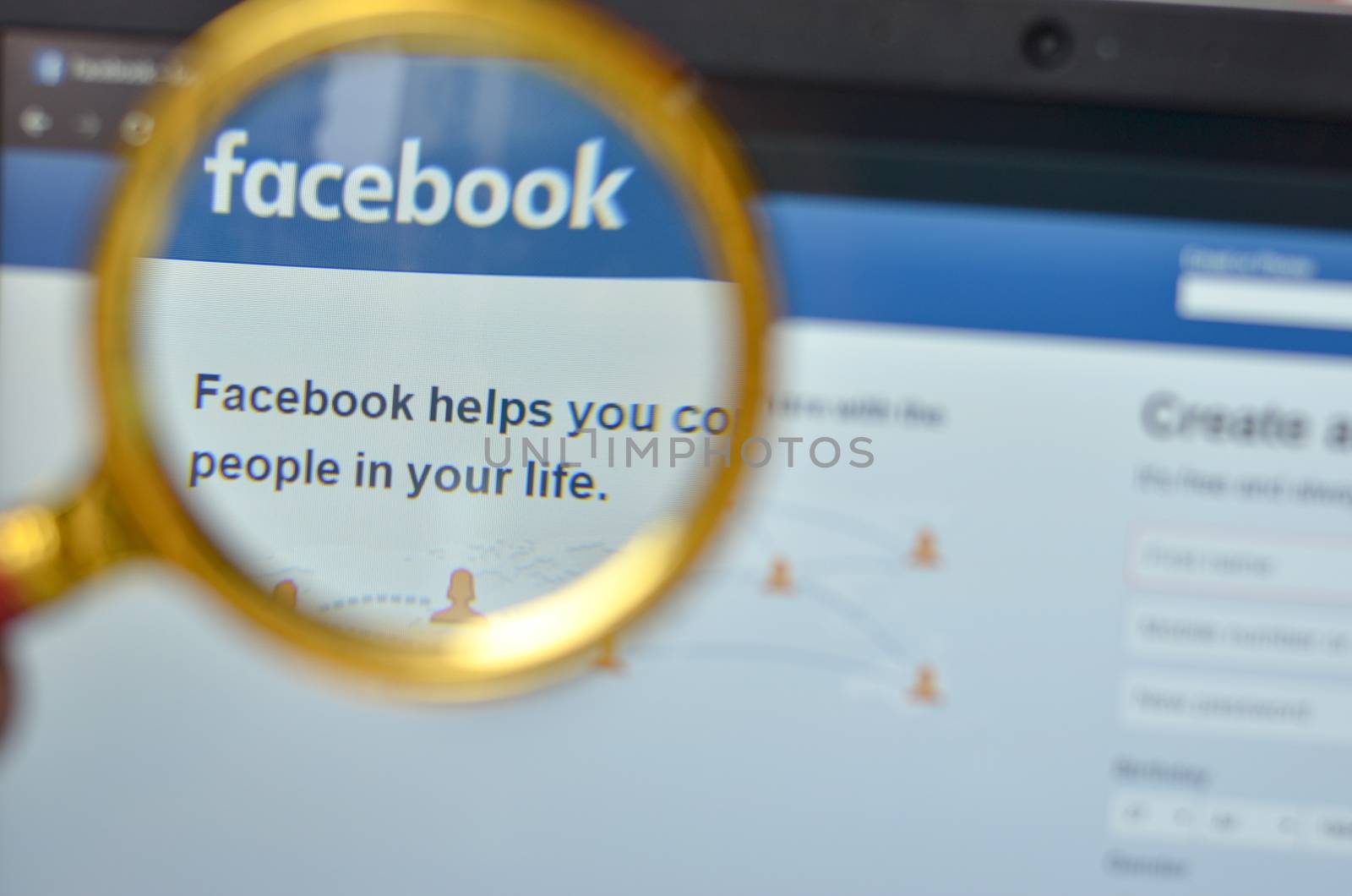 California, USA, 2020. Signup page of Facebook website open on a browser through a magnifying lens. Out of focus laptop screen is in the background. Concept Social Network