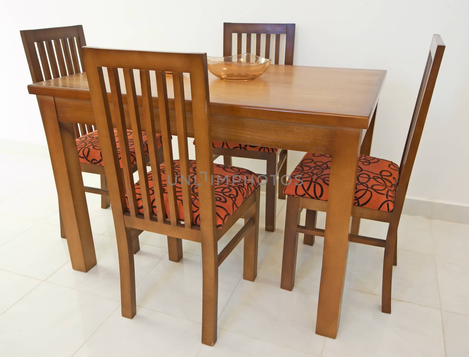 Dining table and four chairs in an apartment against white wall