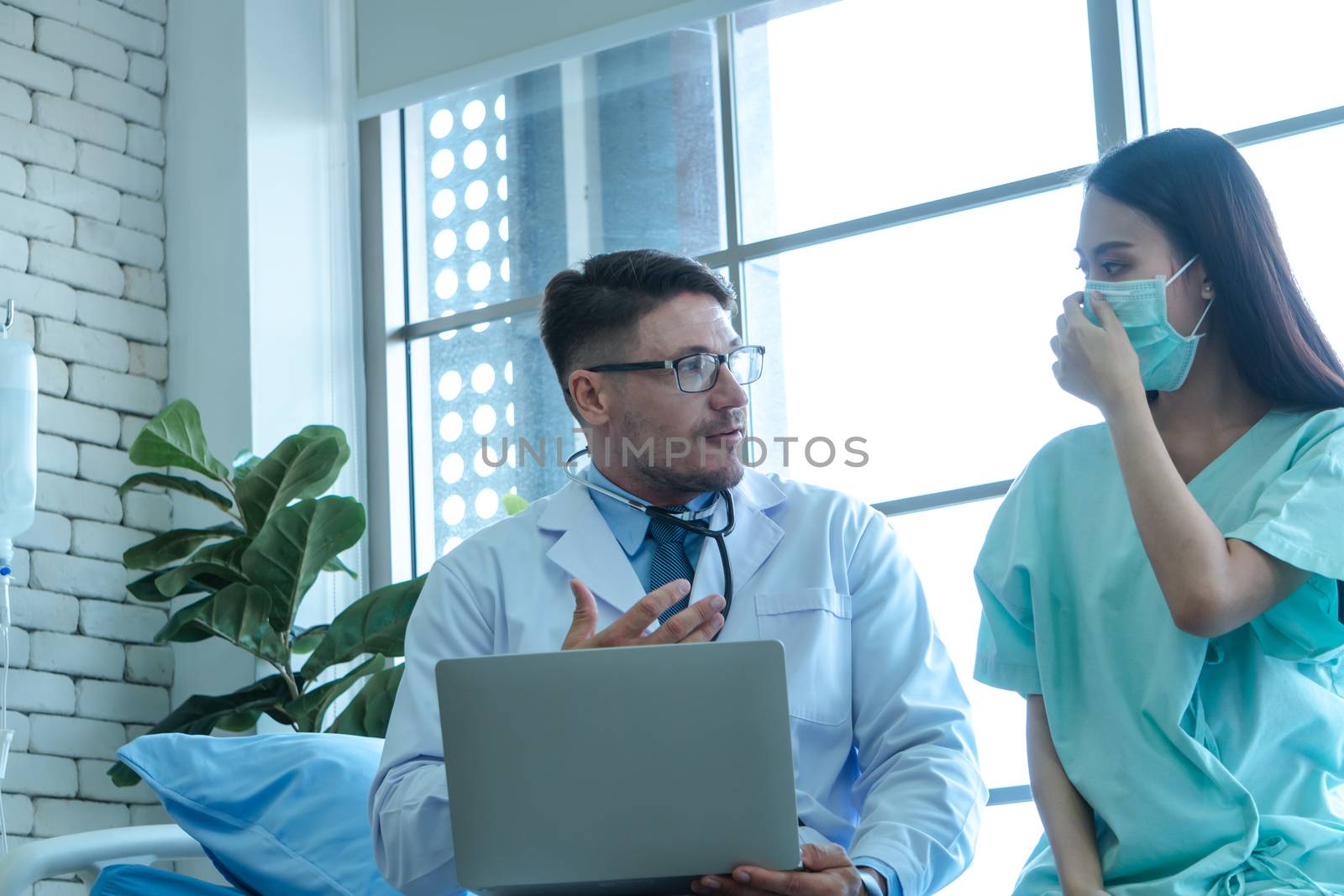 The doctors are checking the patients' symptoms closely. Asian female patients wear masks to prevent and stop the spread of the virus.