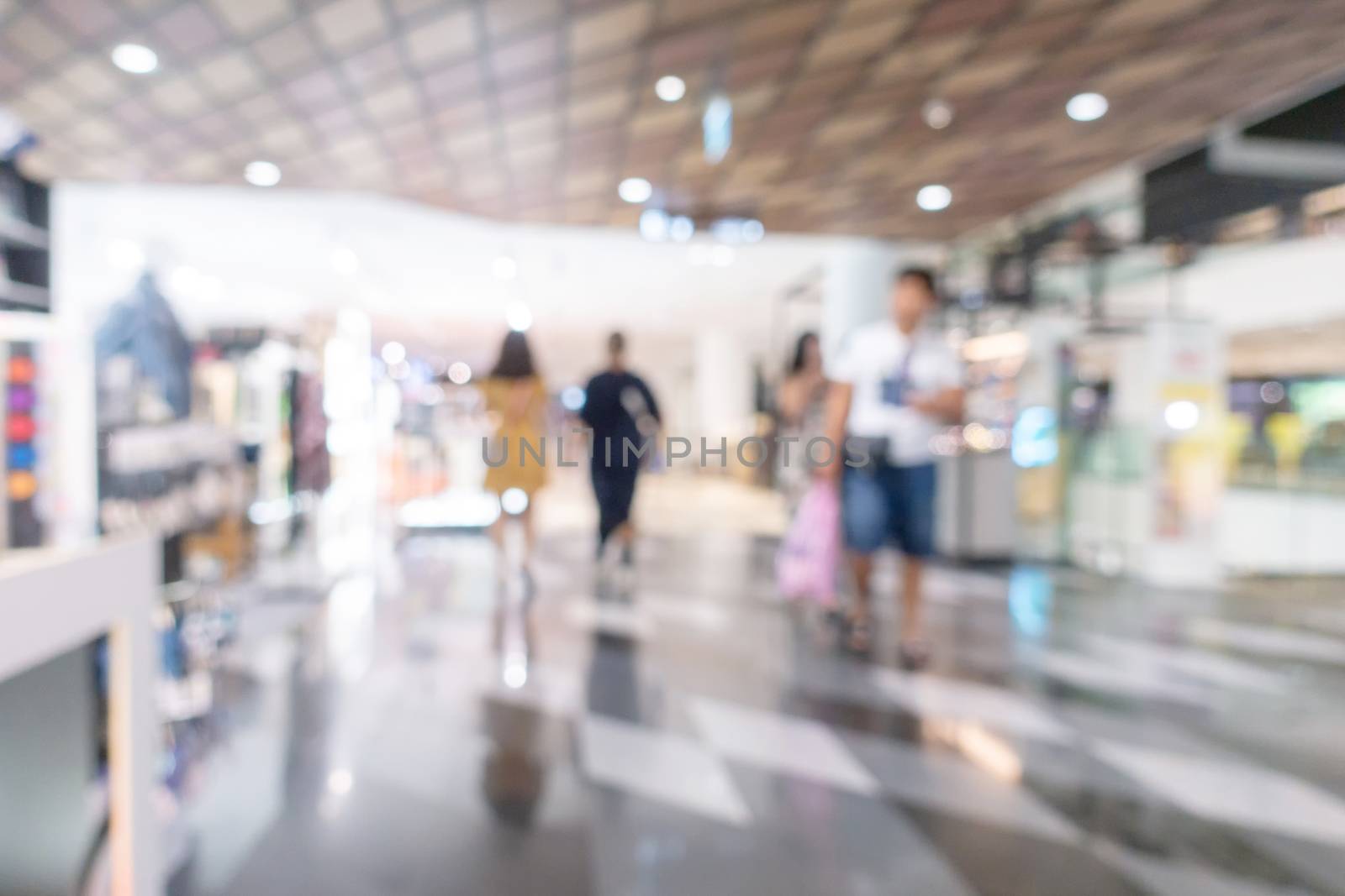 Abstract defocused with bokeh image of shopping mall and people walking for background usage.