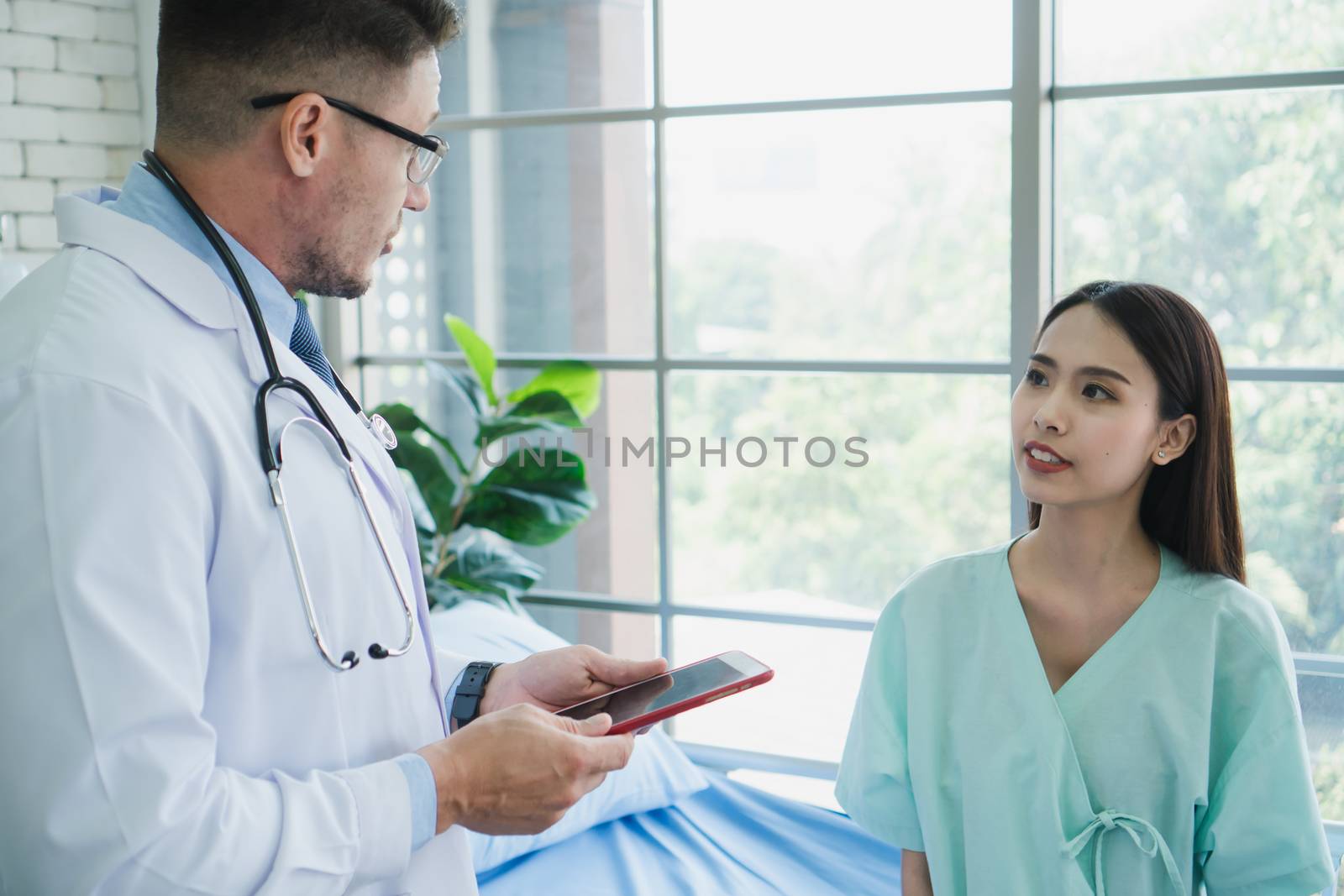 Photos of a male doctor taking care of a female patient and providing health care advice In the patient room of the hospital