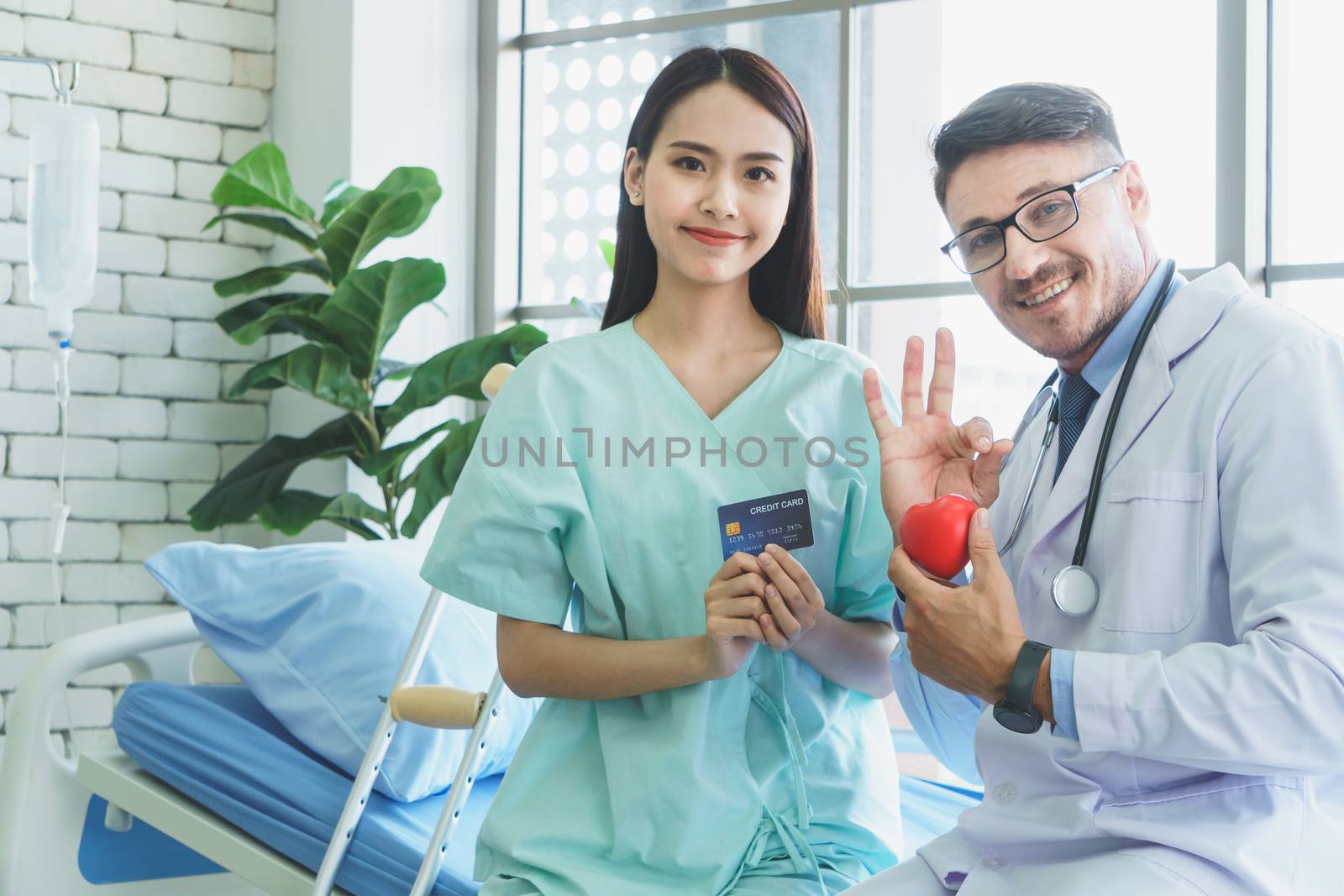 Photos of a male doctor taking care of a female patient and providing health care advice In the patient room of the hospital ( Mockup CREDIT CARD )