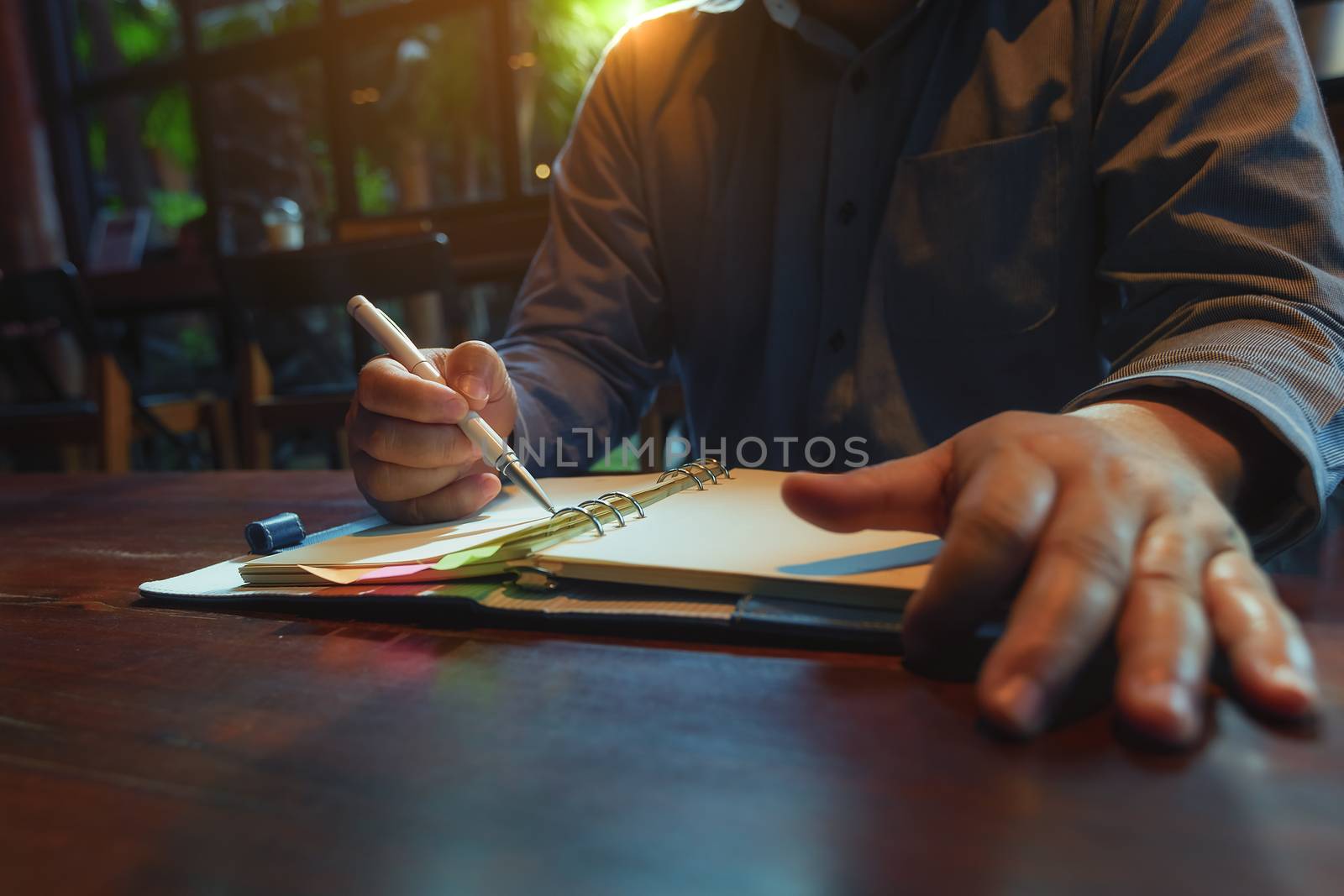 A picture of a business man sitting at a cafe talking in the afternoon of a bright day