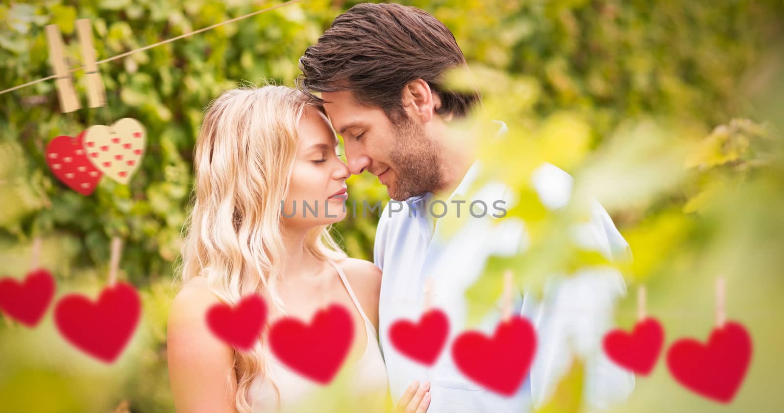 Young romantic couple embracing each other against hearts hanging on a line