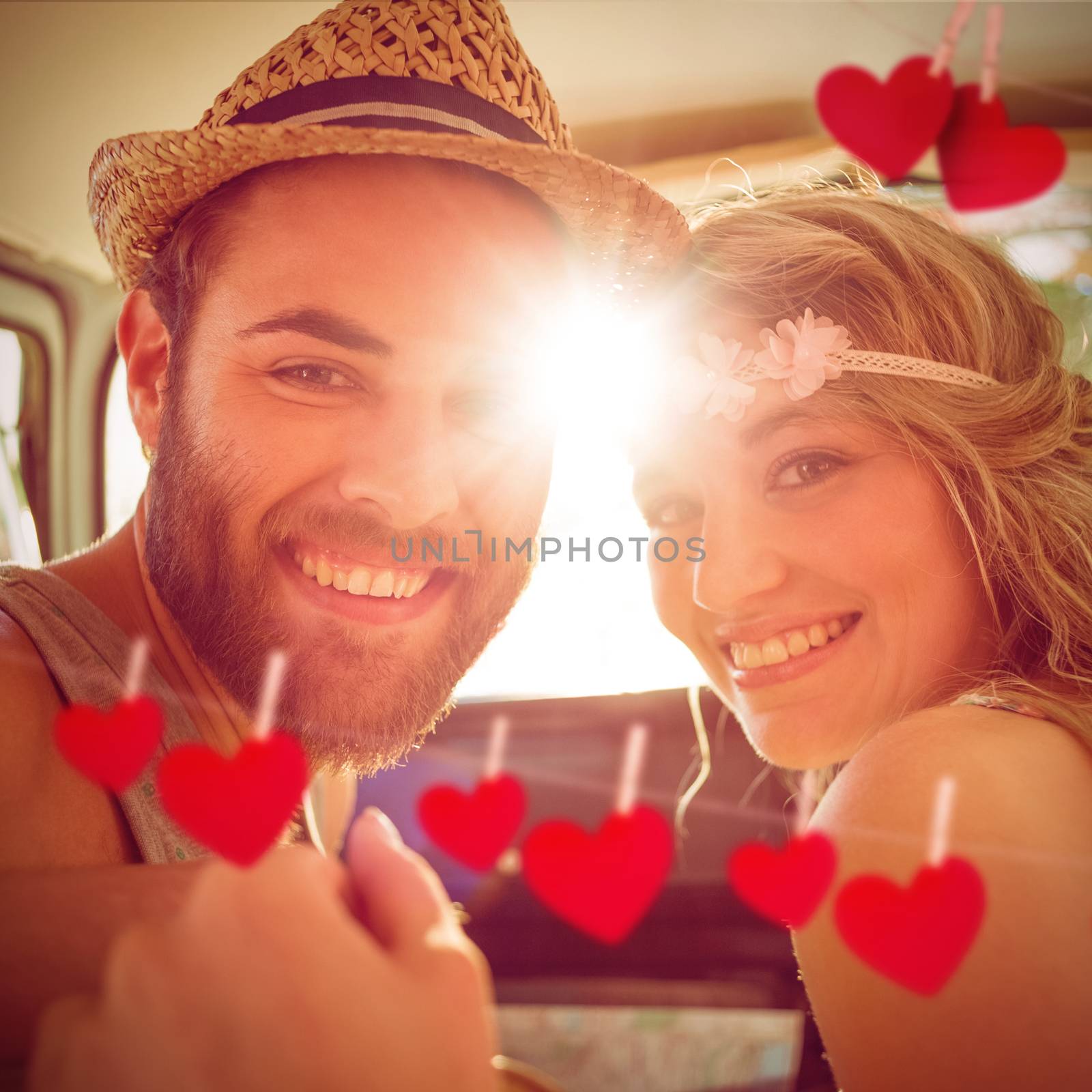 Hipster couple on road trip against hearts hanging on a line