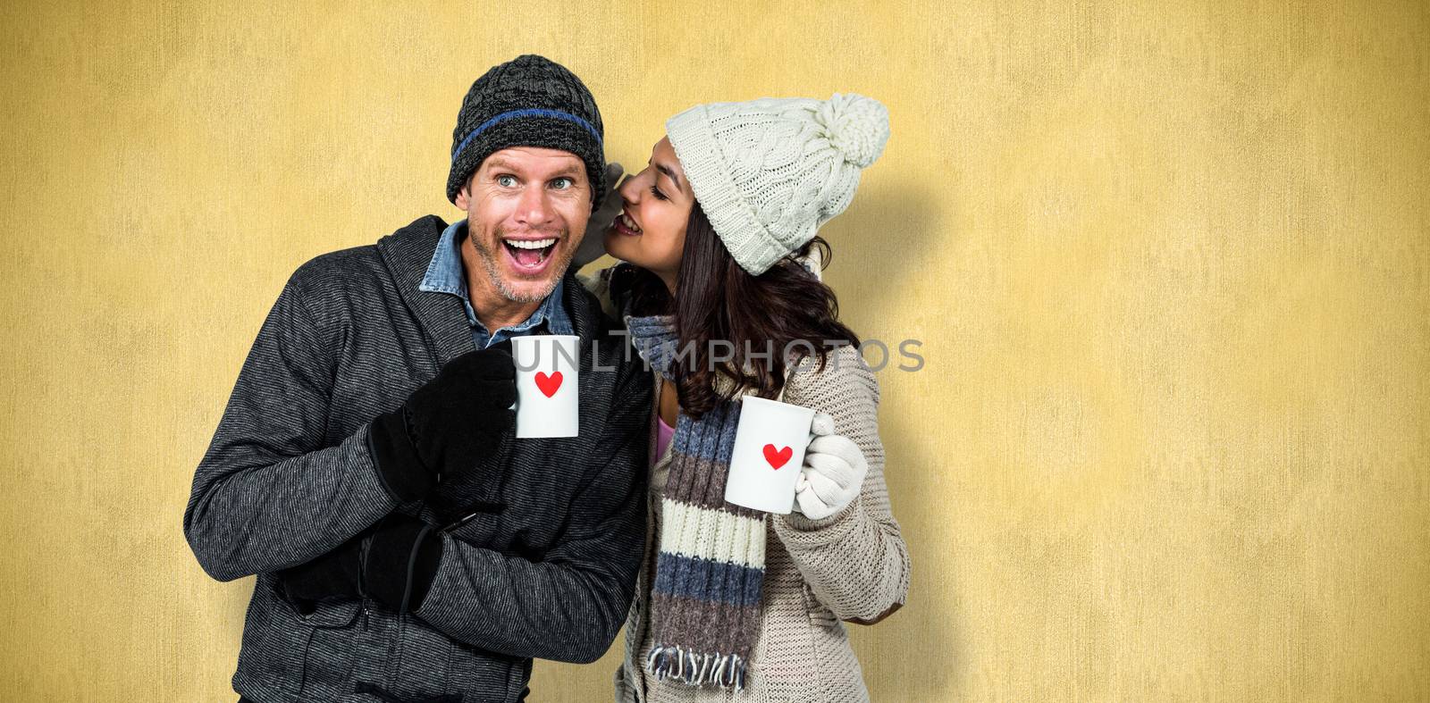 Winter couple enjoying hot drinks against orange background 