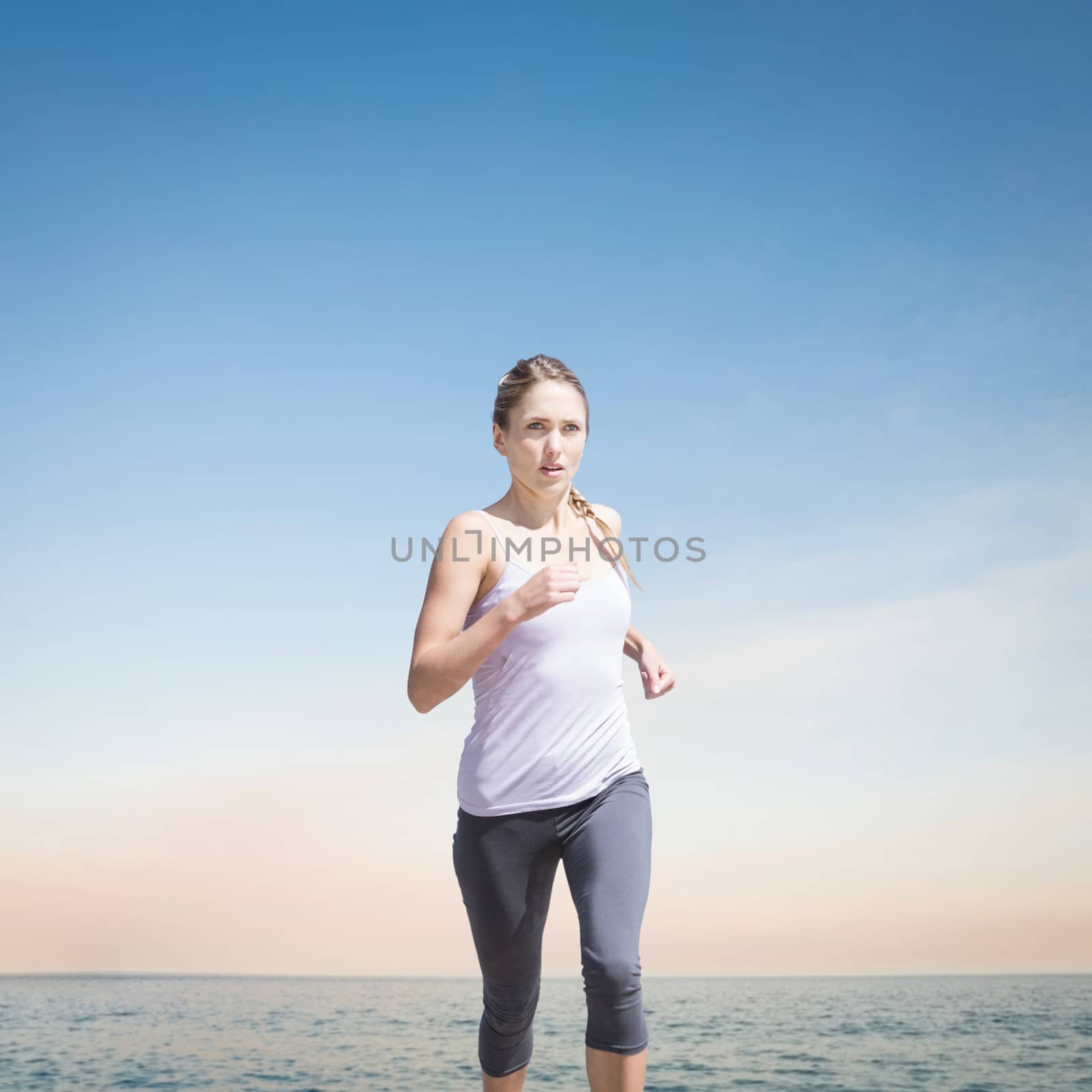 Focused fit blonde jogging  against beautiful sunset on a sunny day