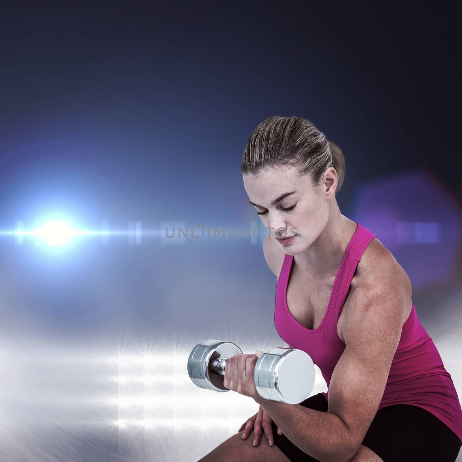 Muscular woman exercising with dumbbells  against spotlights