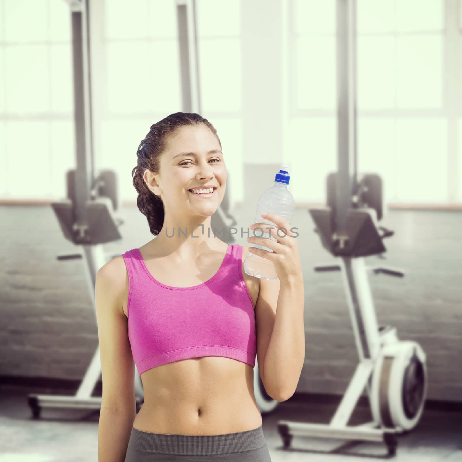 Fit woman with water against four exercise bikes near each others