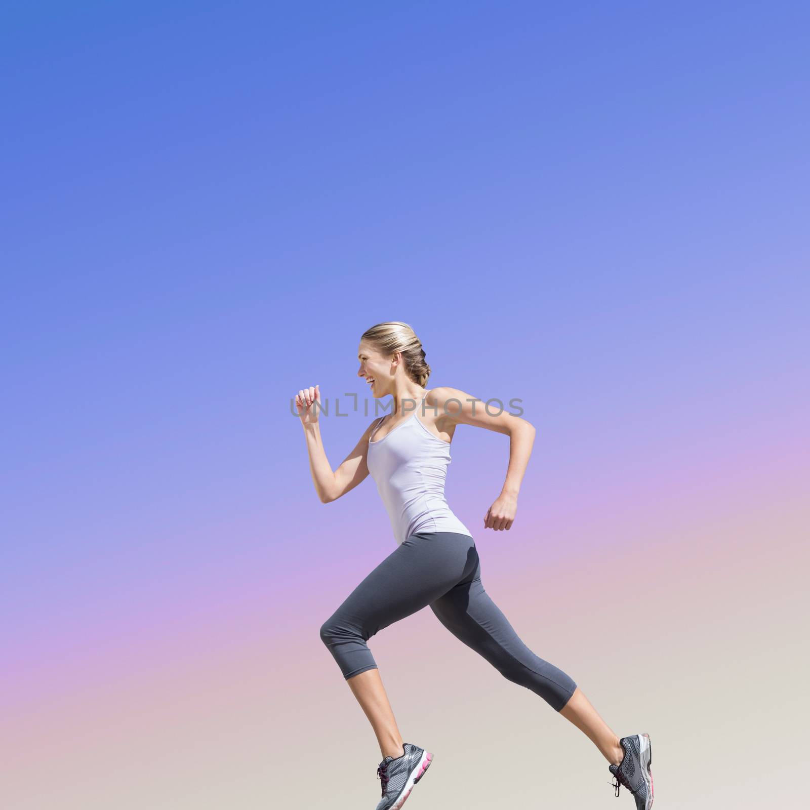 Pretty fit blonde jogging  against purple sky