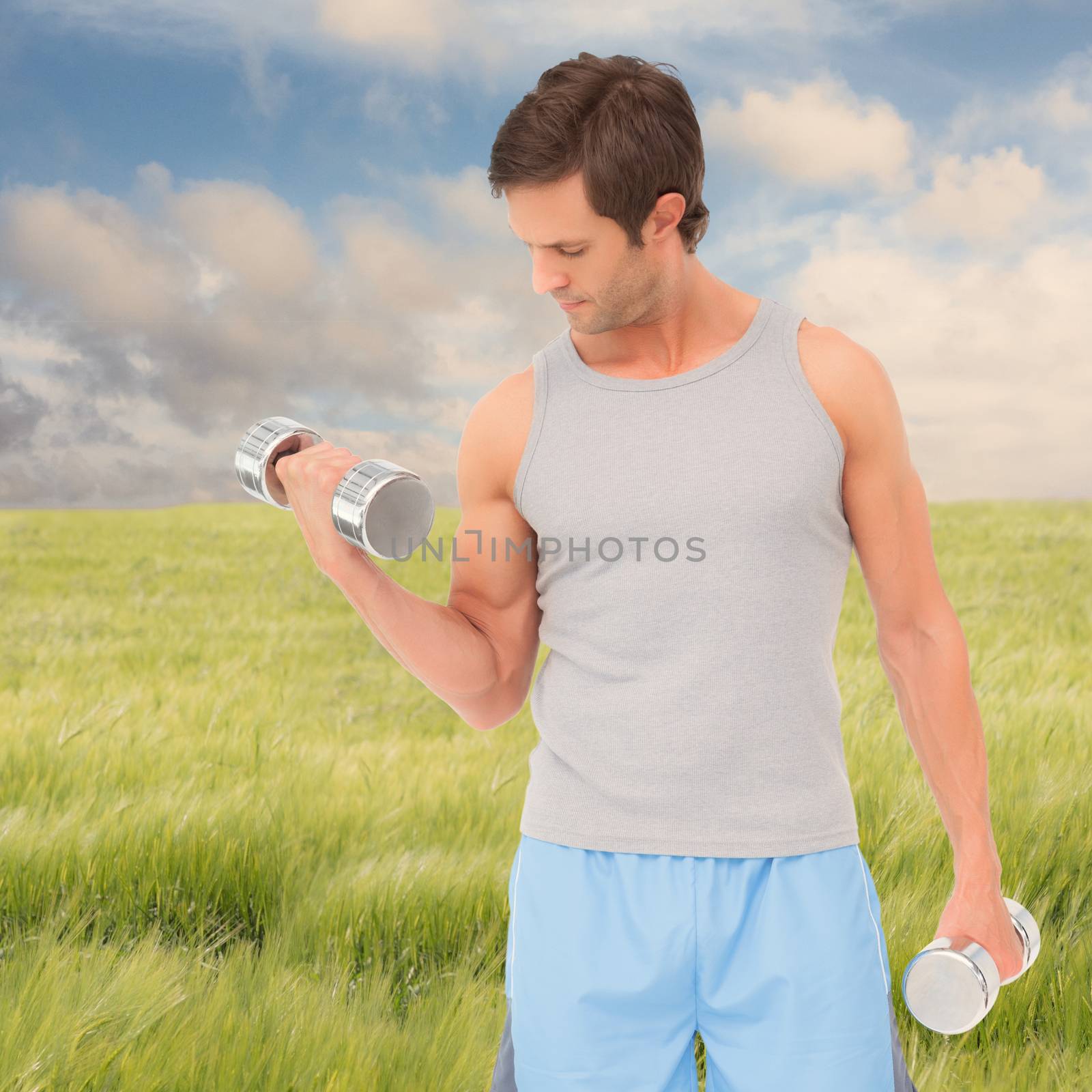 Fit young man exercising with dumbbells against nature scene