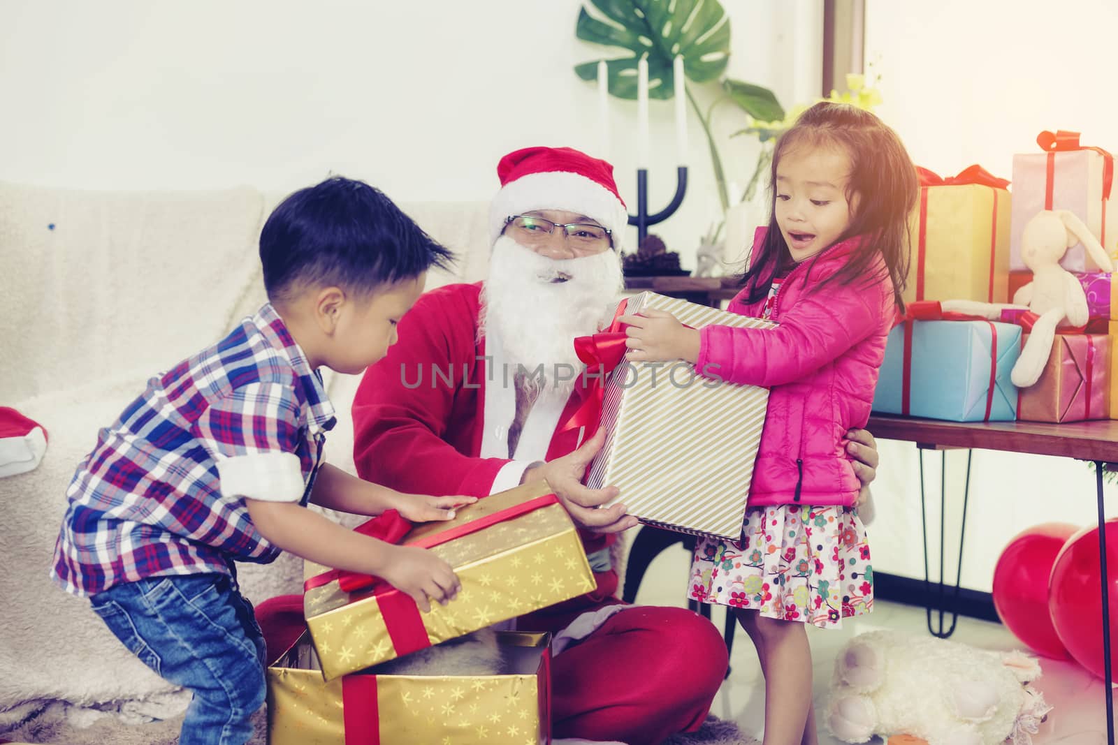 Santa Claus gives gifts to girls and boys during the Christmas season.