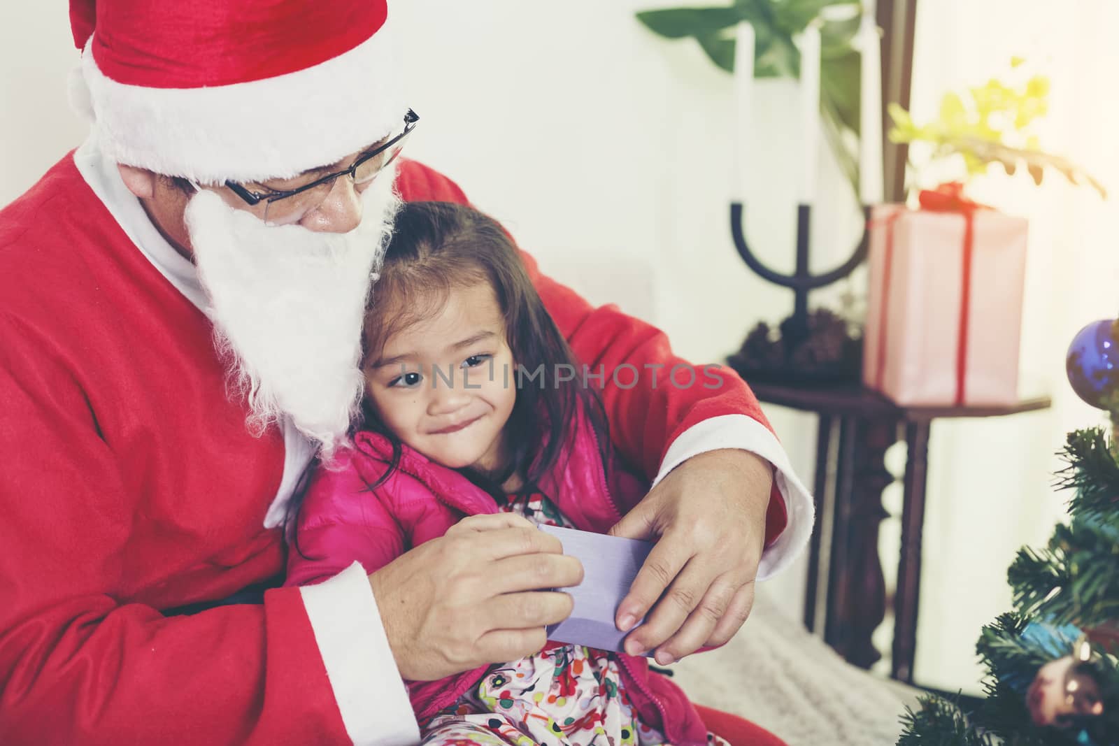 Santa Claus gives gifts to girls and boys during the Christmas season.