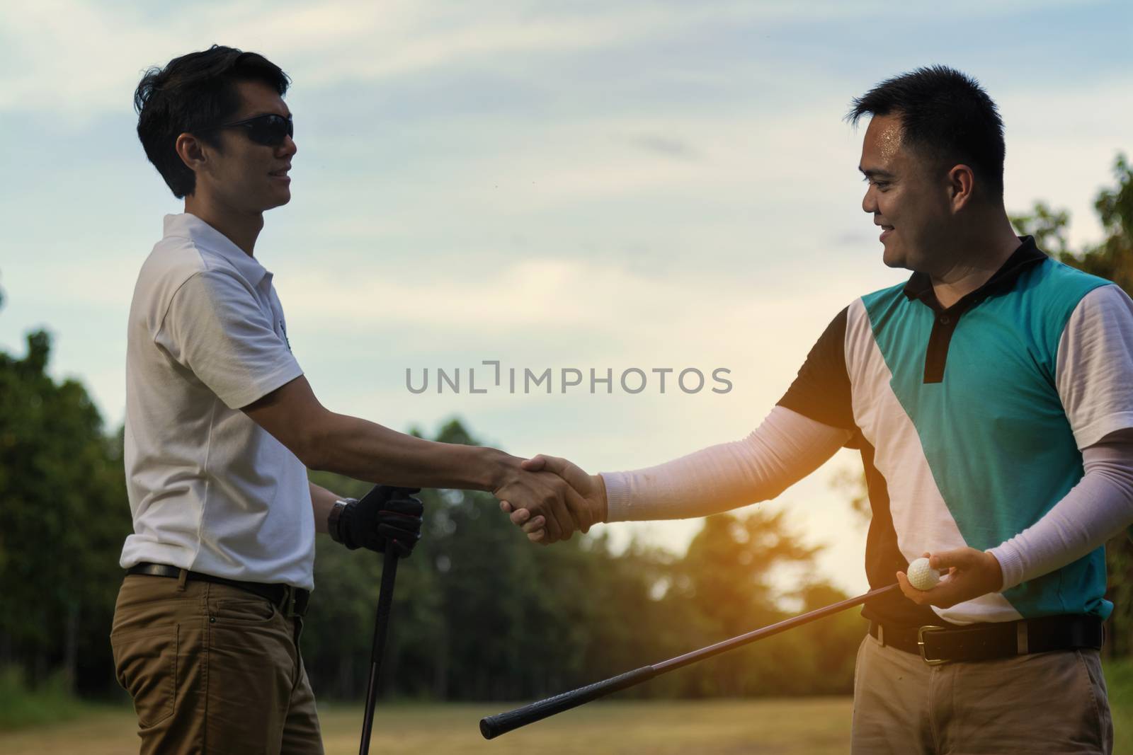 Young handsome businessman shake hands on the golf course and ne by numberone9018