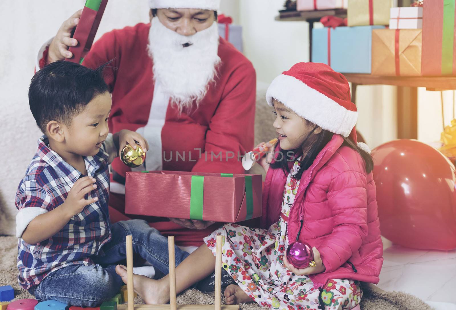 Santa Claus gives gifts and reads fairy tales to boys and girls listening in the festive season.