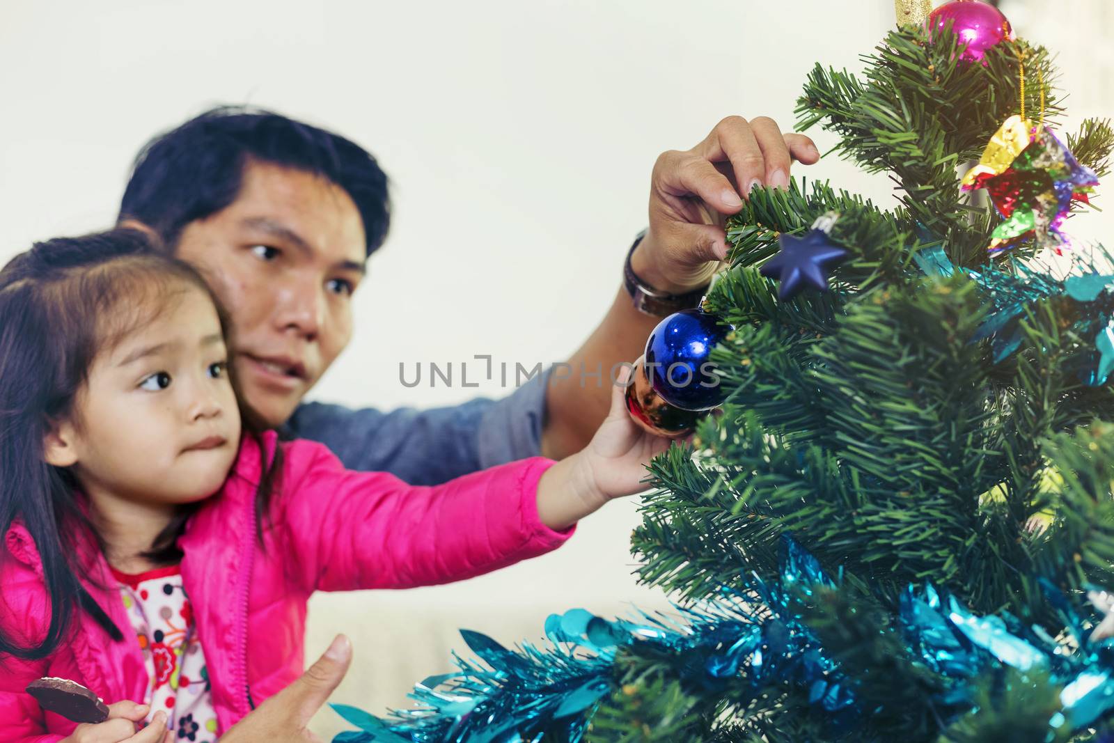 Father and son help to decorate the Christmas tree.