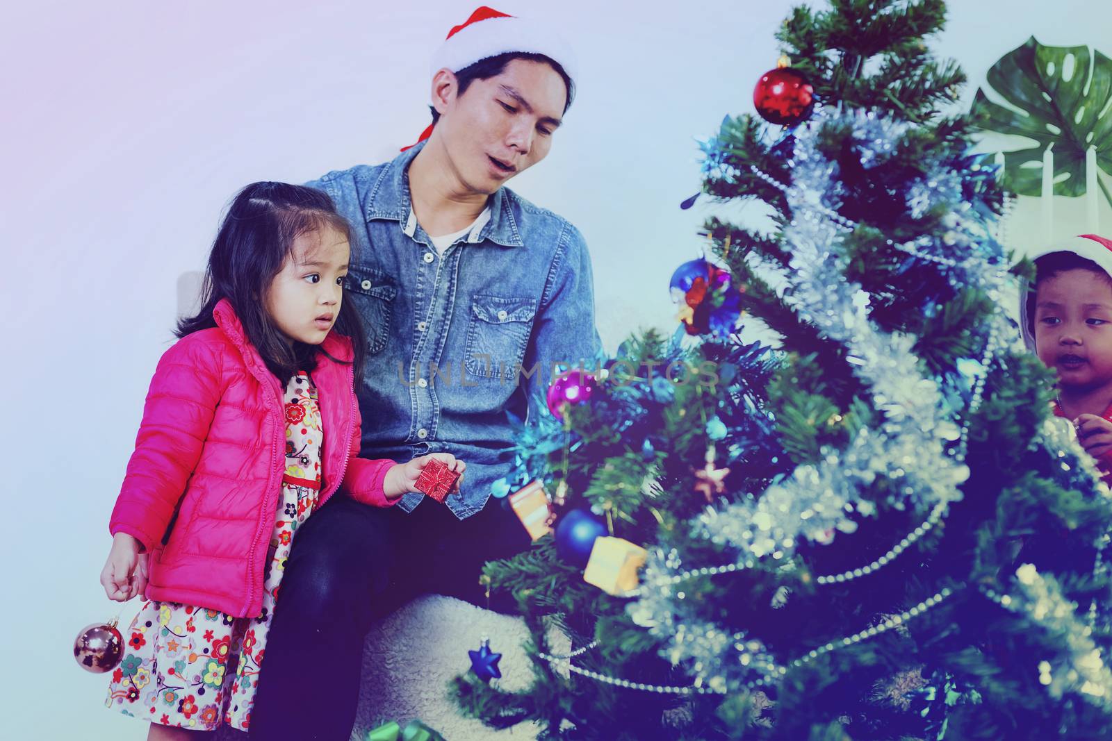 Father and son help to decorate the Christmas tree.