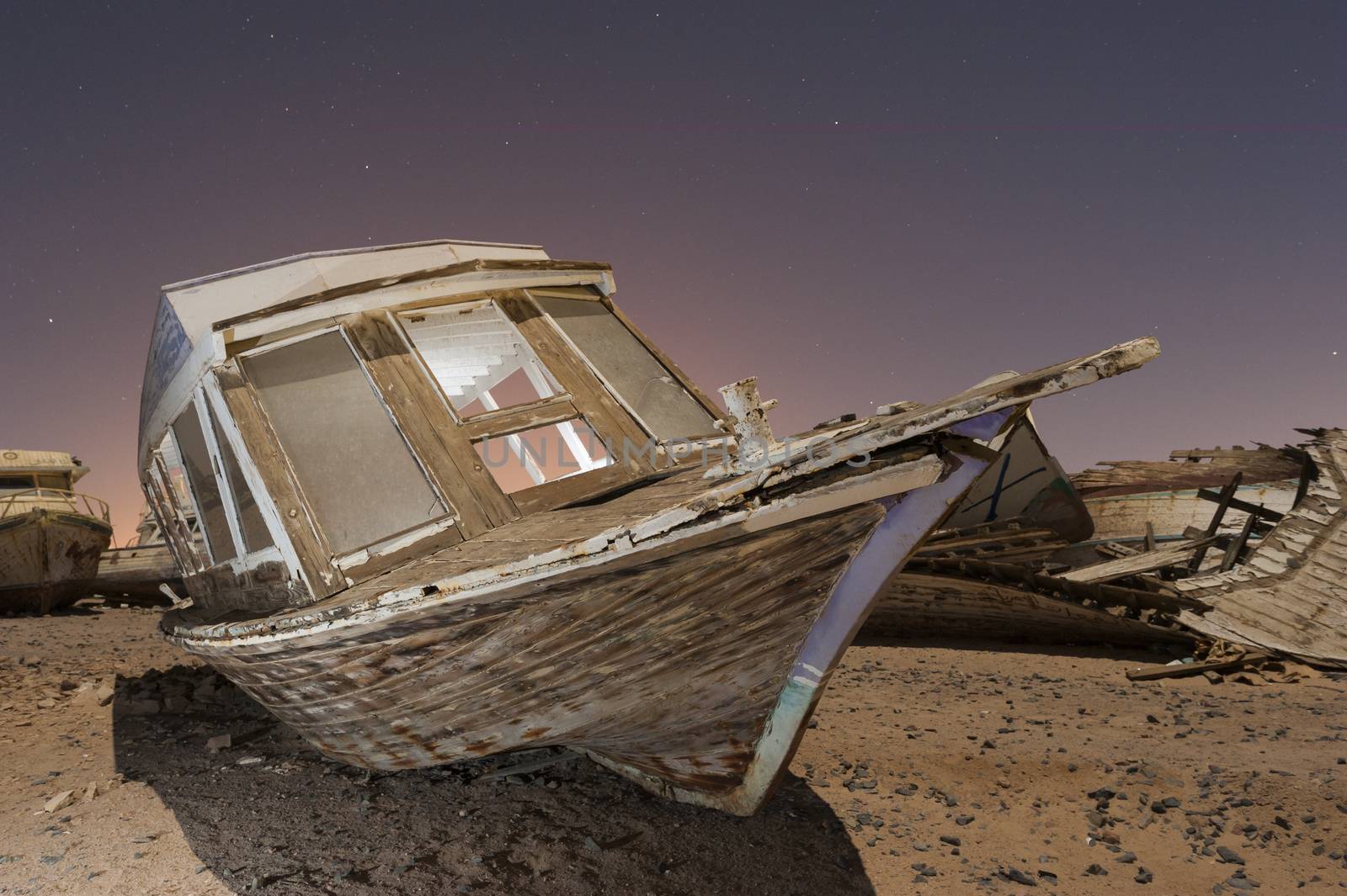 Derelict boats in the desert at night by paulvinten