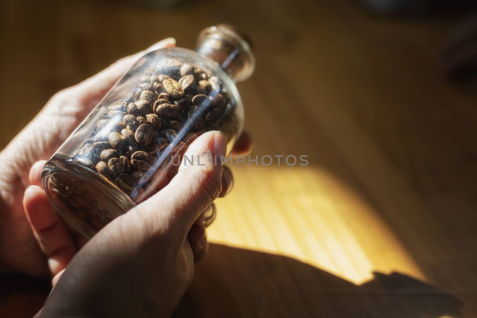 Close-up image of hand holding coffee beans in glass bottles by numberone9018