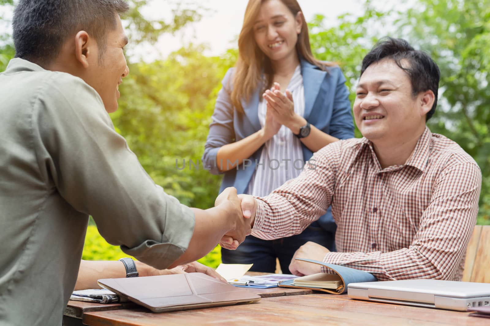 Young business men are negotiating with customers. And shake hands after the negotiations.