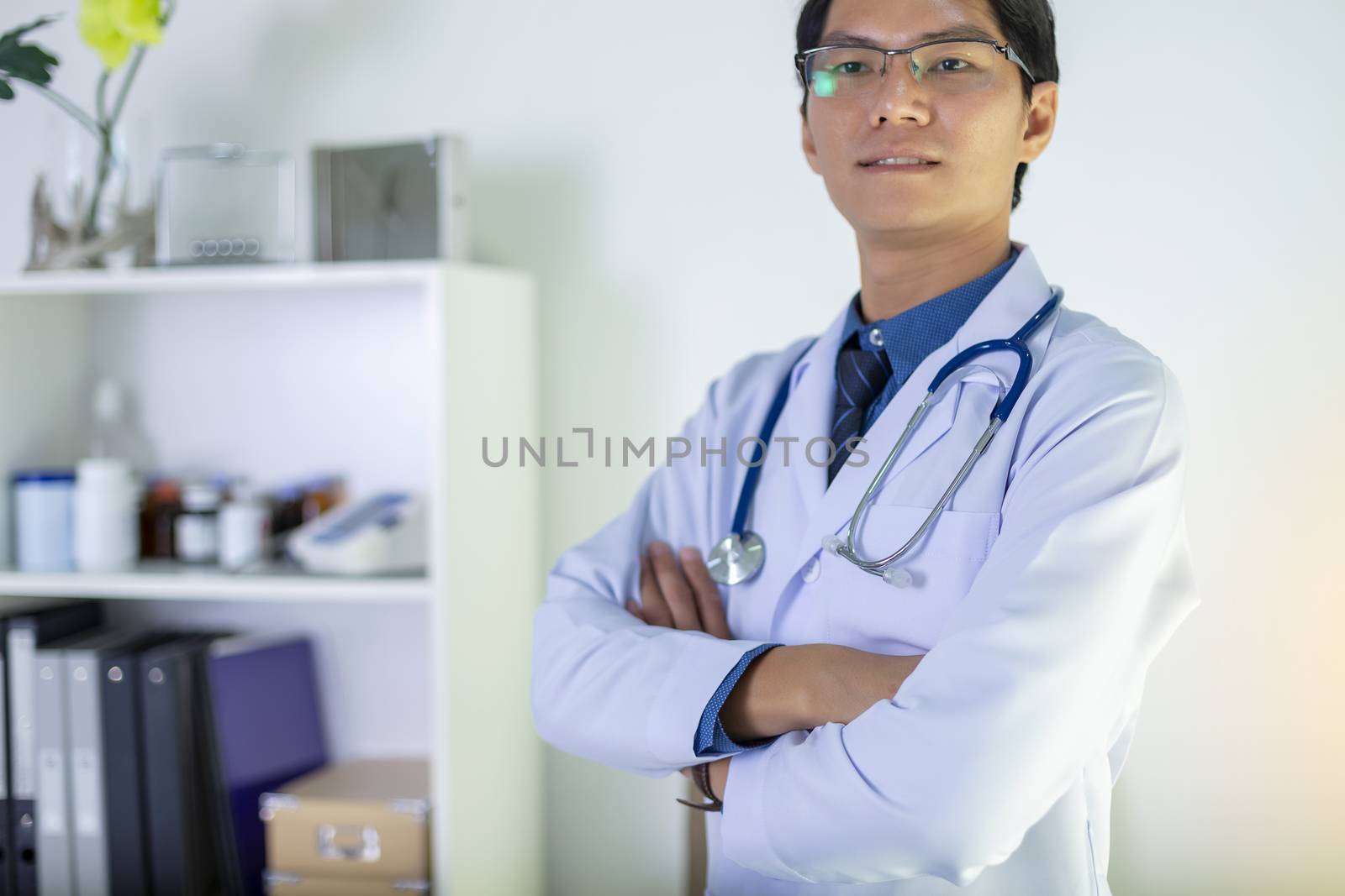 Portrait of doctor standing in his private clinic. Medical physician doctor man over clinic background. Doctor.