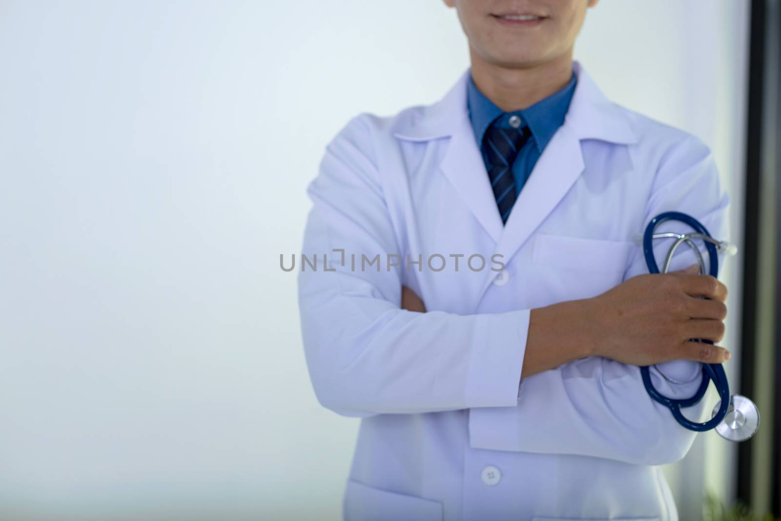 Portrait of doctor standing in his private clinic. Medical physician doctor man over clinic background. Doctor.