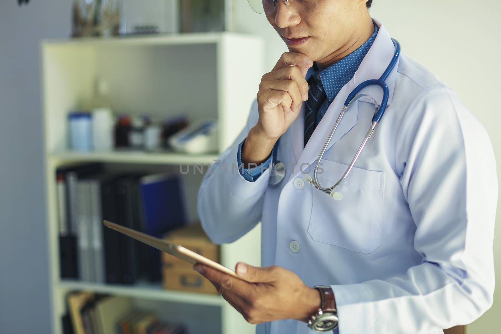 Portrait of doctor standing in his private clinic. Medical physician doctor man over clinic background. Doctor.