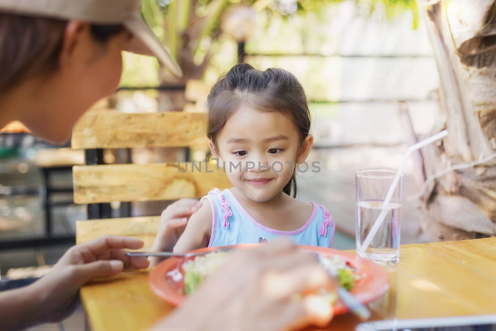 Close up Thai children eating in restaurant with her mother by numberone9018