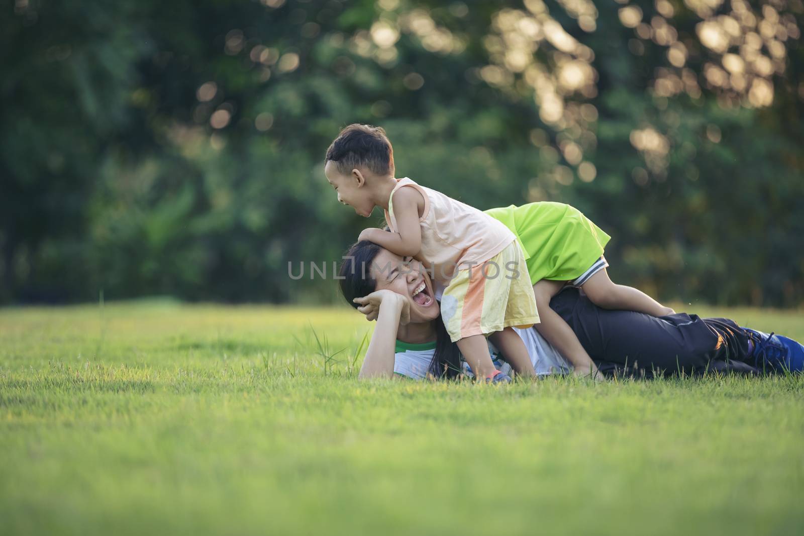 Happy family playing in the park. Mother and son play together in nature in the summer