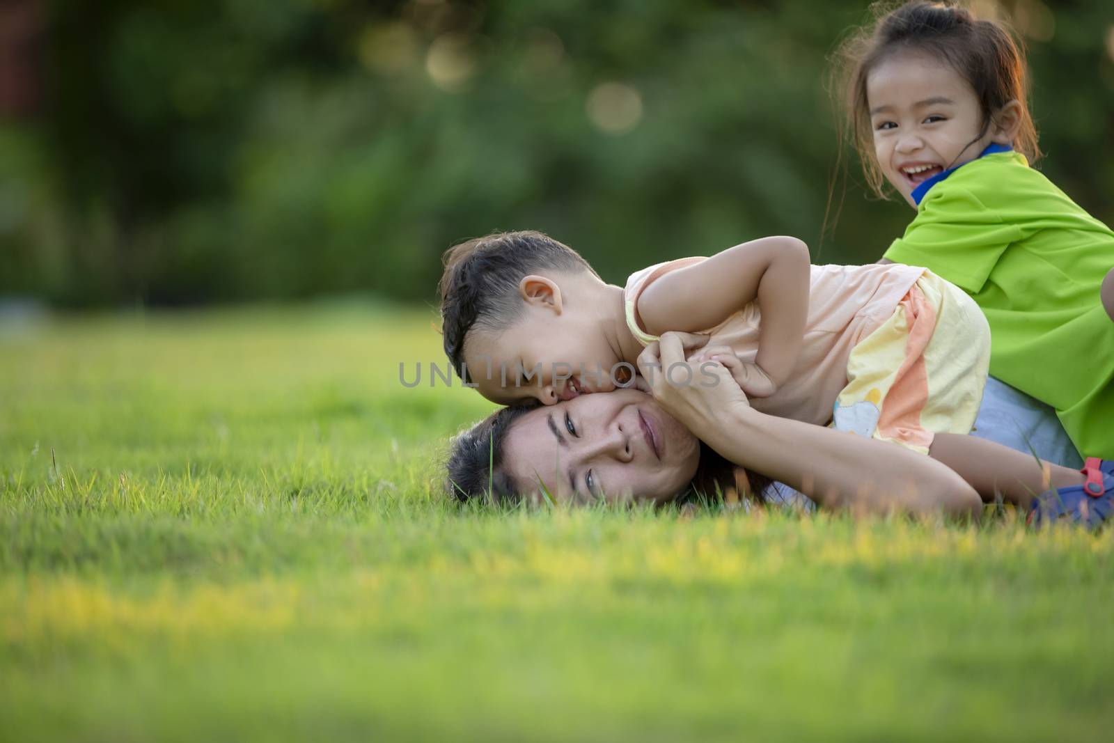 Happy family playing in the park. Mother and son play together in nature in the summer