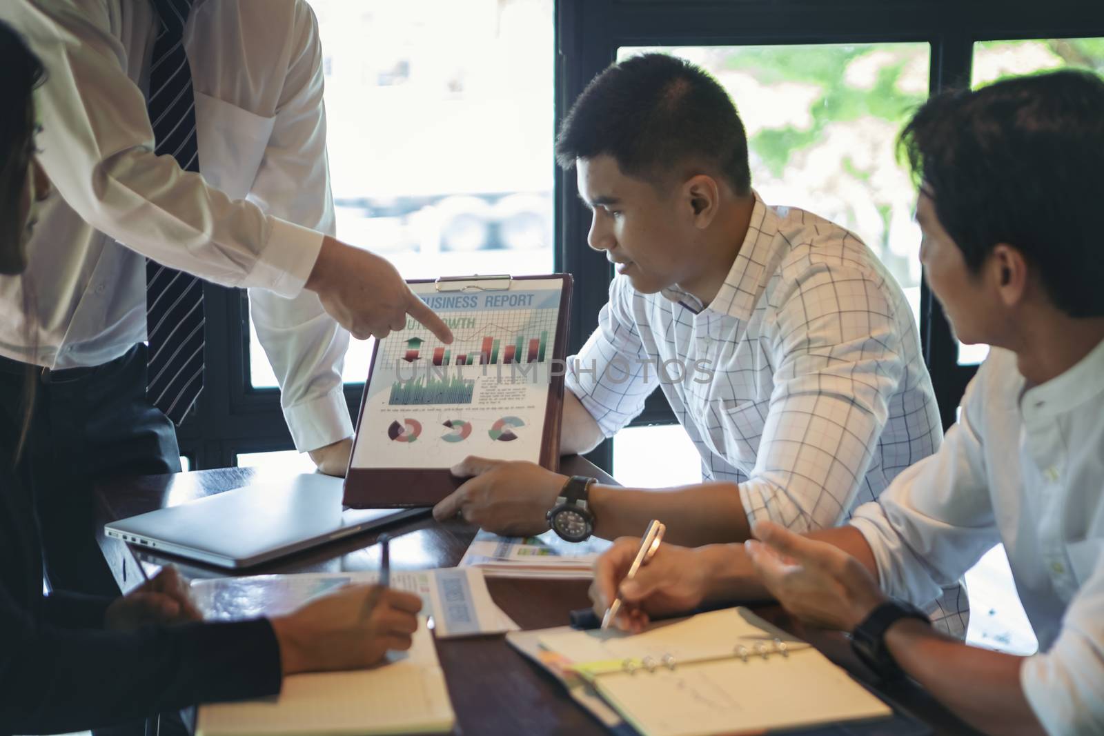 Successful businessman boss presenting new project to employees, businessman giving presentation to clients in meeting room, team leader reporting about work explaining result on flipchart. 