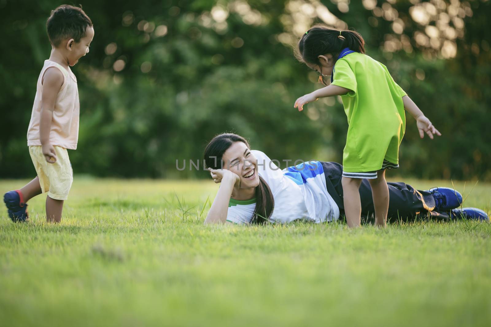 Happy family playing in the park. Mother and son play together i by numberone9018