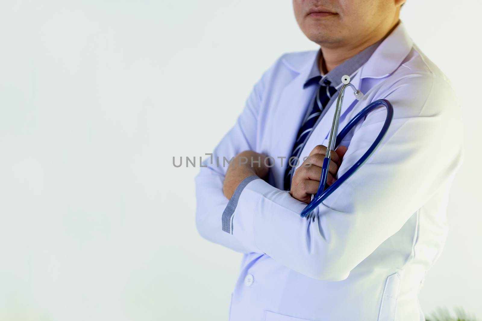 Portrait of doctor standing in his private clinic. Medical physician doctor man over clinic background. Doctor.