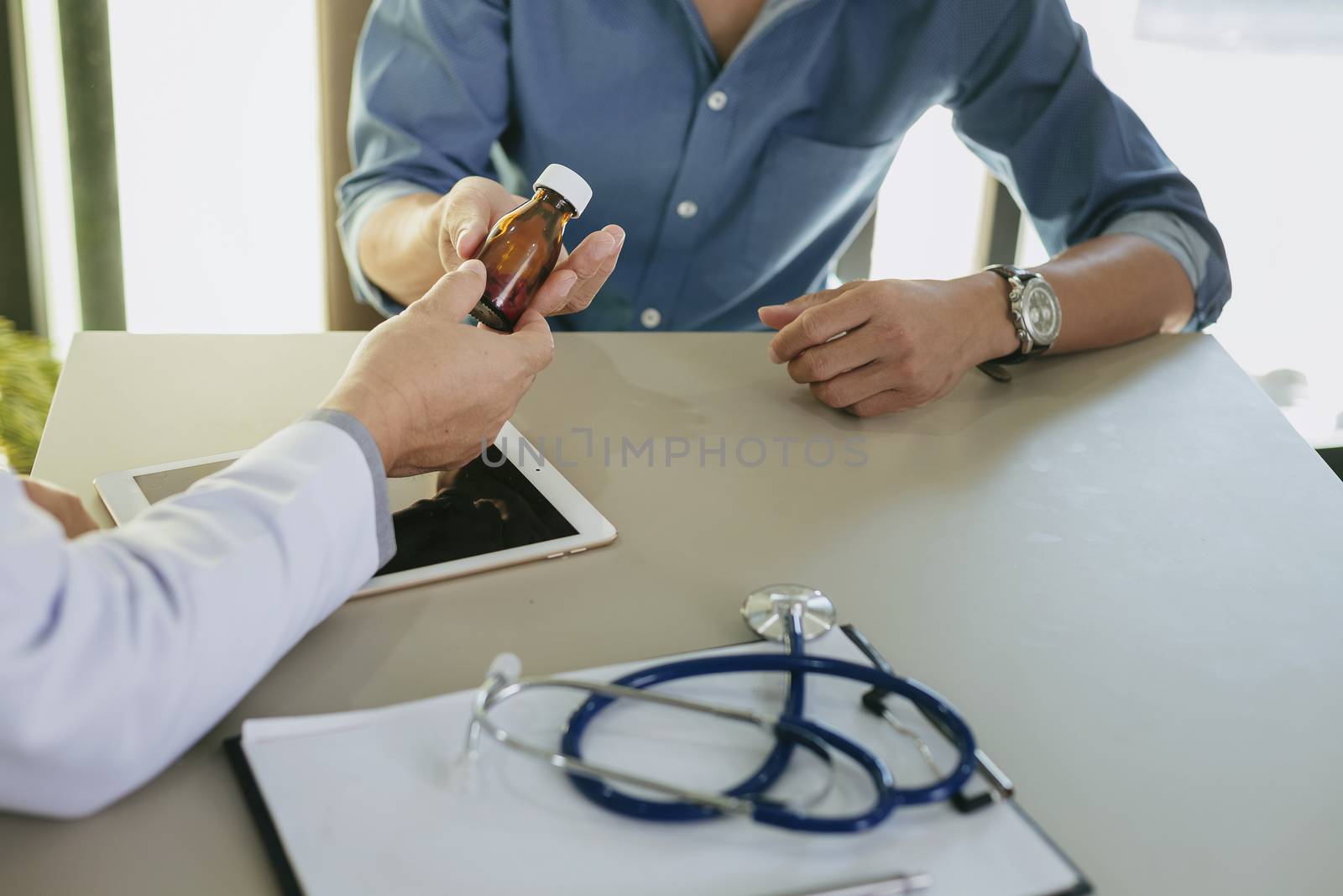 The doctor is explaining something about the medicine to the patient, in order to understand how to use it and to know the benefits and penalties of the drug.