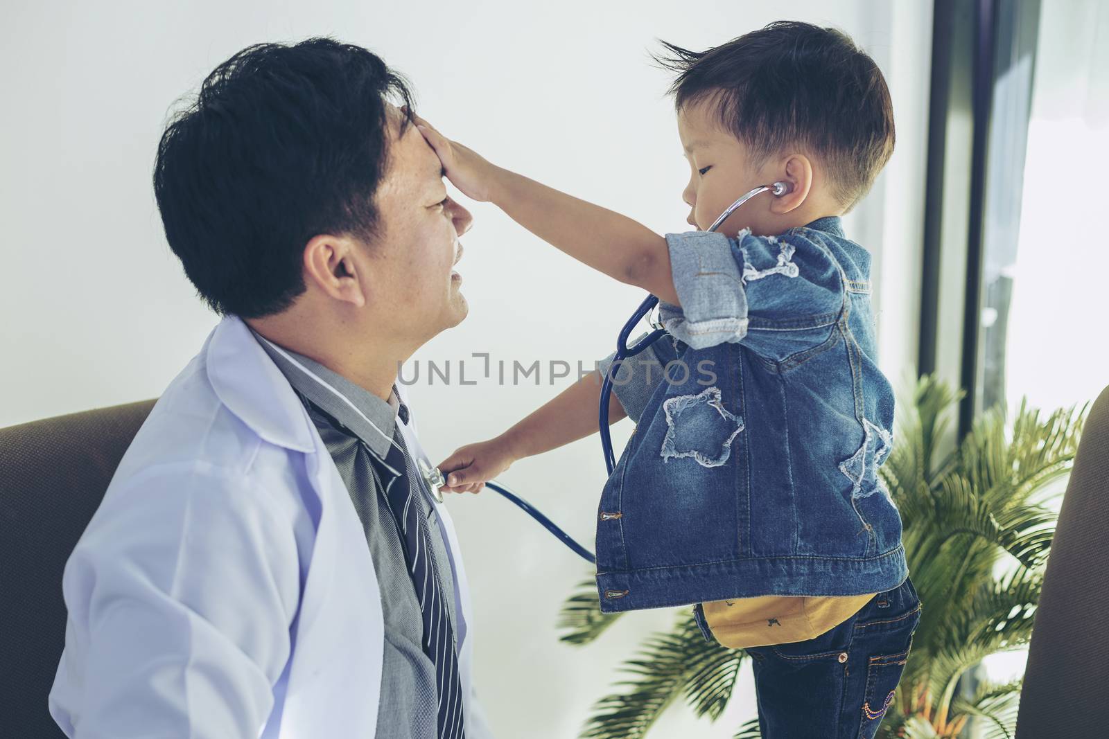 Doctor examining a little boy by stethoscope. Medicine and health care concept.