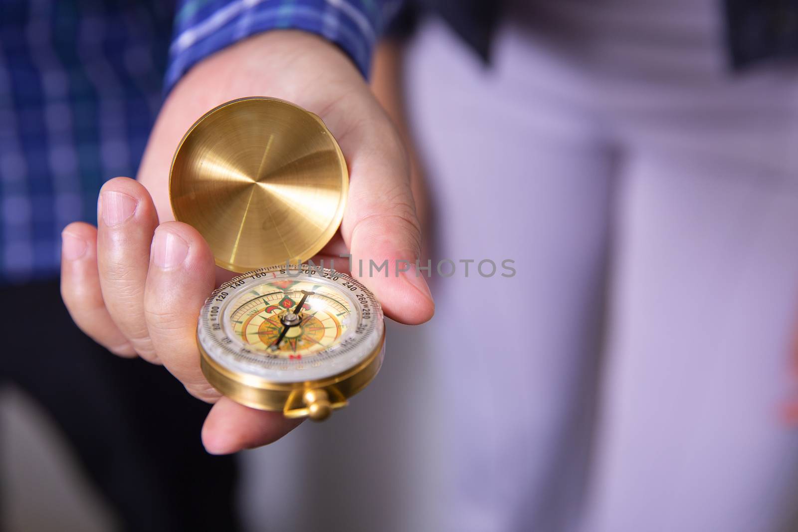 Close up of a businessman holding a compass in his hand. Business direction and movement concept. Selective focus.