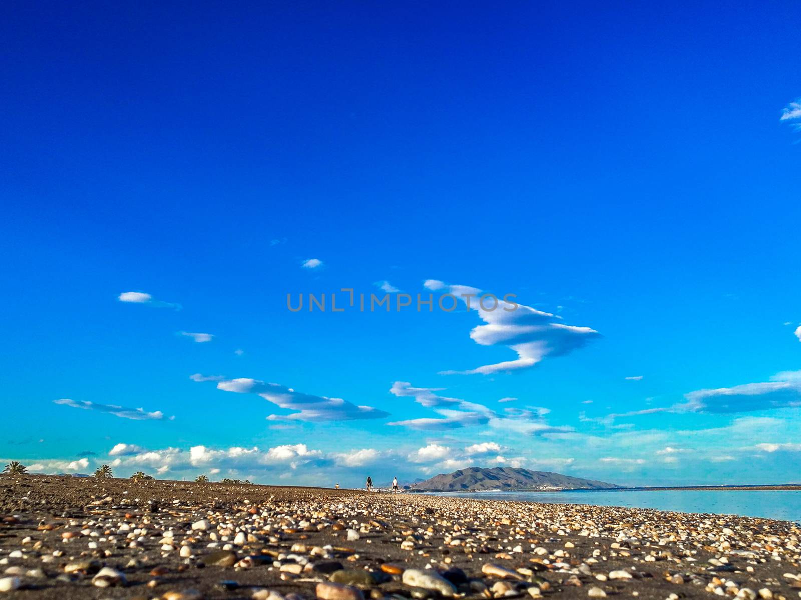Perspective of Sandy beach with little stone. Blue turqoise waters in spanish coasts